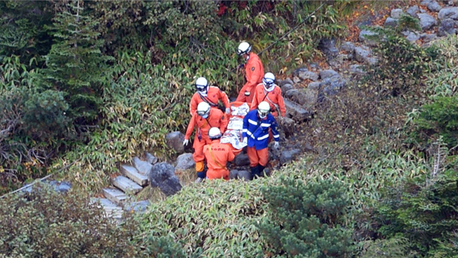 October 1, 2014: Rescuers carry a person found on Mount Ontake in central Japan. Search efforts for people missing since Saturday's surprise eruption resumed Wednesday morning. (AP Photo/Kyodo News)