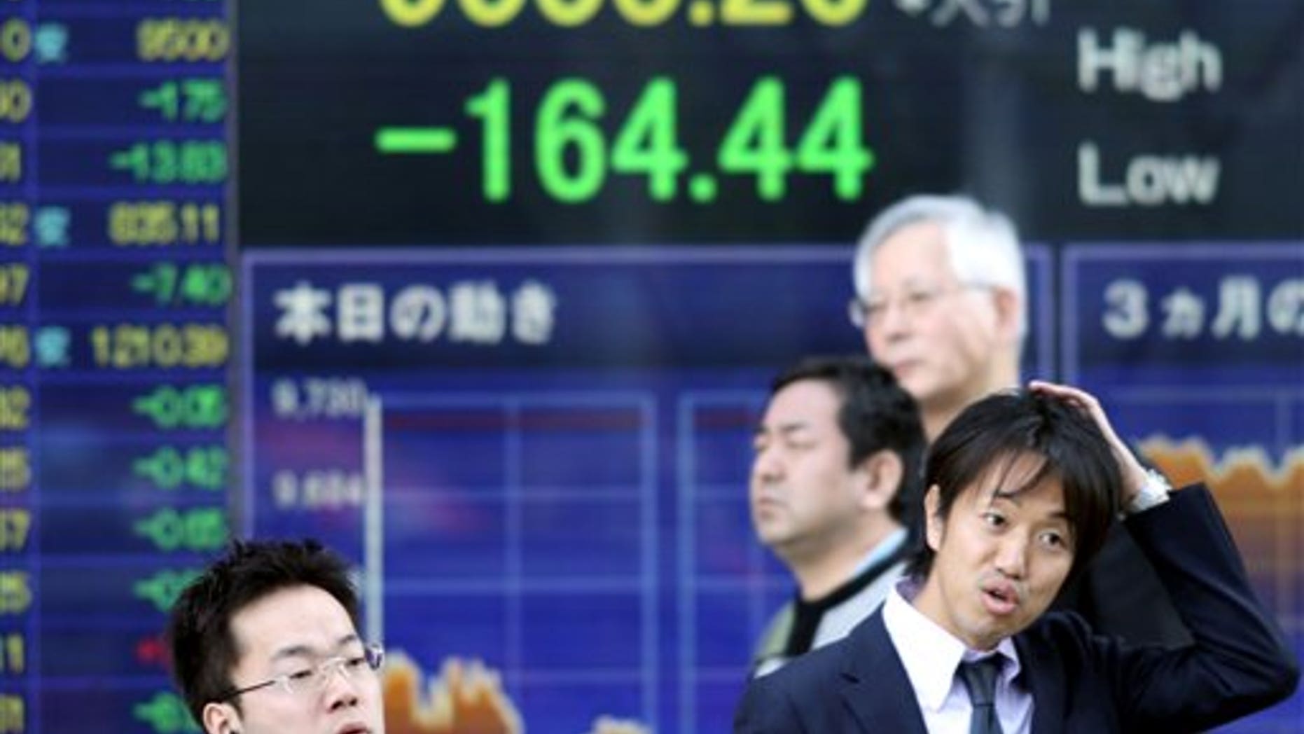 April 12: People in front of an electronic stock board at a securities firm in Tokyo.