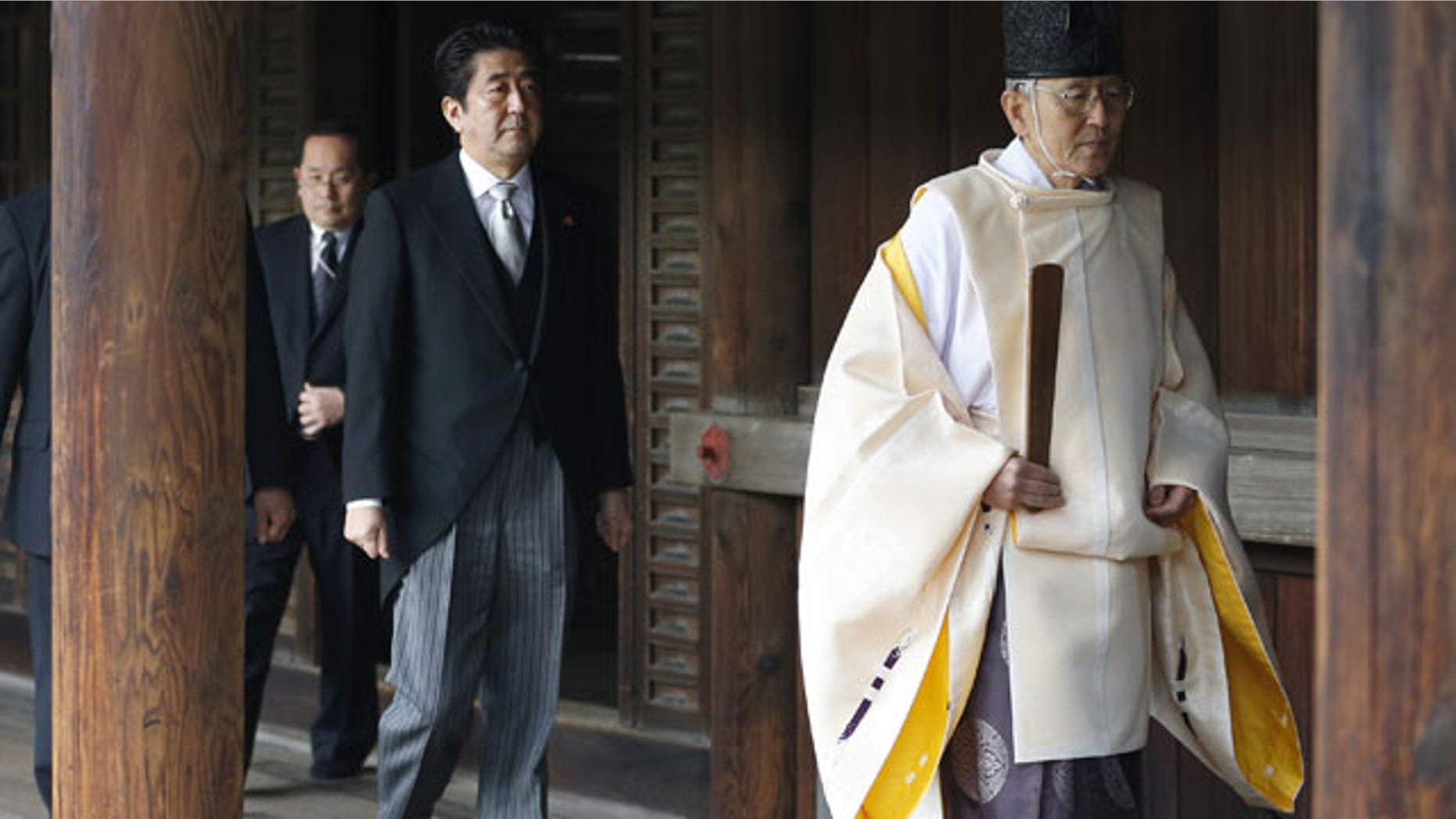 December 26, 2013: Japanese Prime Minister Shinzo Abe, second from right, follows a Shinto priest to pay respect for the war dead at Yasukuni Shrine in Tokyo. The visit to the shrine, which honors 2.5 million war dead including convicted class A war criminals, appears to be a departure from Abe’s “pragmatic” approach to foreign policy, in which he tried to avoid alienating neighboring countries. (AP)