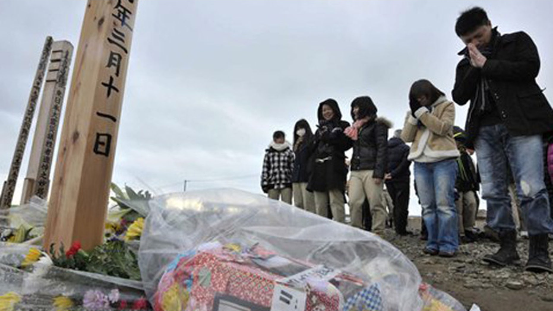 Mar. 11, 2012: People offer prayers to mourn the victims of the March 11, 2011 earthquake and tsunami on a hill in Natori, Miyagi prefecture, Japan.
