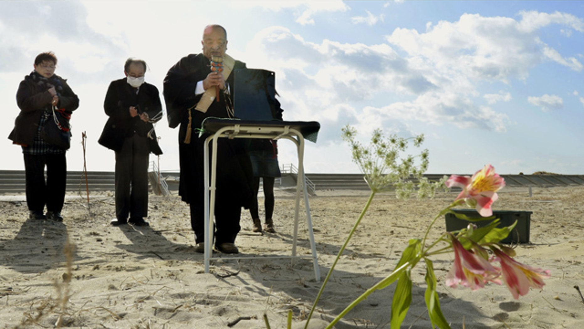 Mar. 11, 2013: People offer prayers as a Buddhist monk chants a sutra for tsunami victims in a private ritual to mark the second anniversary of the 2011 earthquake an tsunami on a beach in Arahama in Sendai, Miyagi Prefecture, Japan.