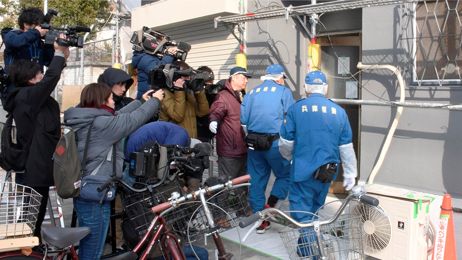 Hyogo Prefectural authorities enter a lodging facility where the severed head of a woman was found, after an American man was arrested on suspicion of confining the missing 27-year-old woman.