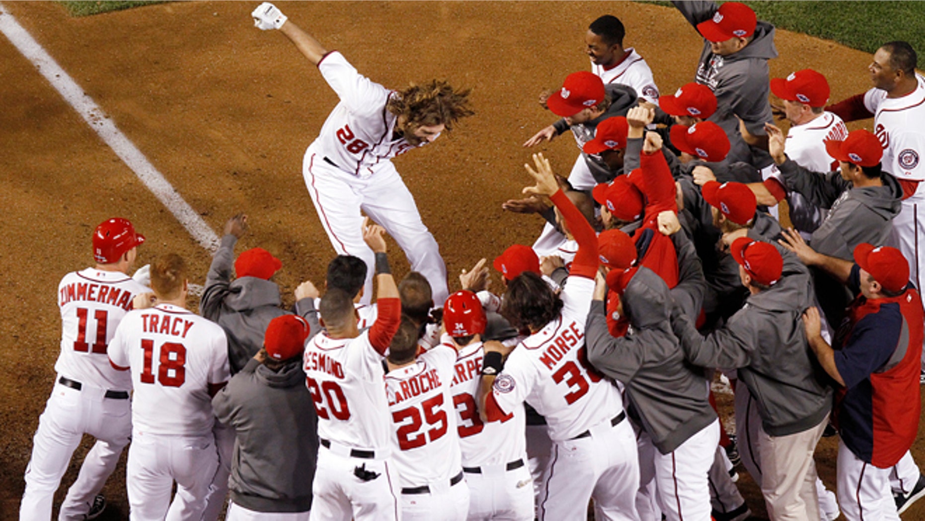 Washington Nationals' Jayson Werth leaps onto home plate after hitting a walk-off home run in the ninth inning against the St. Louis Cardinals in Game 4 of the National League baseball division series, Thursday, Oct. 11, 2012, in Washington.