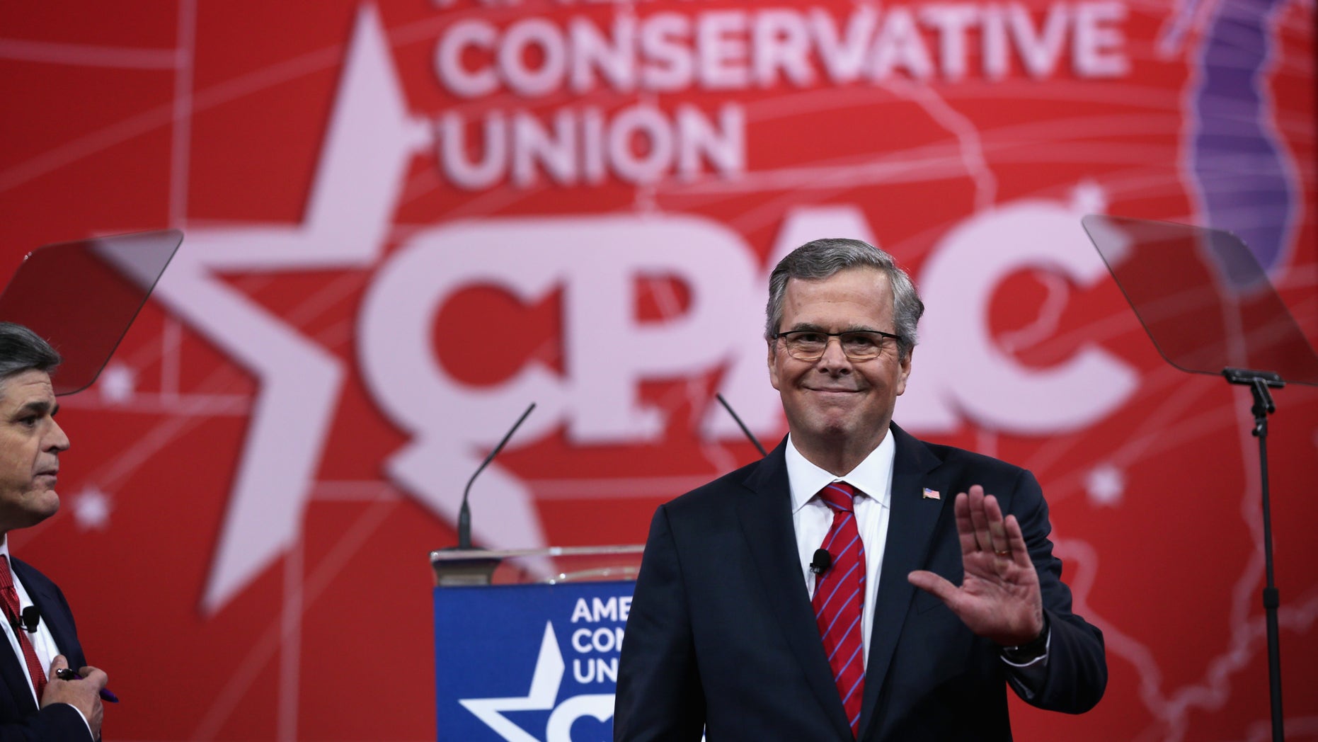 NATIONAL HARBOR, MD - FEBRUARY 27: Former Florida governor Jeb Bush (R) waves to the crowd as Sean Hannity (L) of Fox News looks on at the 42nd annual Conservative Political Action Conference (CPAC) February 27, 2015 in National Harbor, Maryland. Conservative activists attended the annual political conference to discuss their agenda. (Photo by Alex Wong/Getty Images)