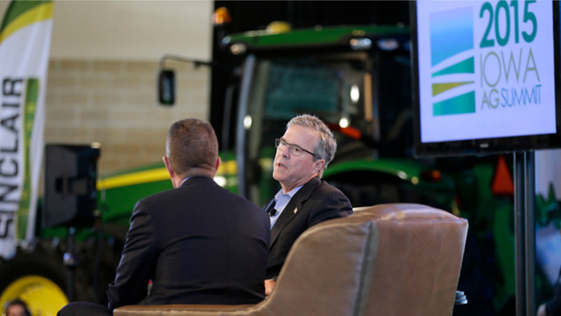 In this March 7, 2015, photo, former Florida Gov. Jeb Bush is interviewed by host Bruce Rastetter, left, during the Iowa Agriculture Summit in Des Moines, Iowa. After a flurry of fundraising, formal speeches about economics and global affairs Bush got down to business this weekend appearing at the Pizza Ranch in Cedar Rapids, Iowa, after a stop at the Agricultural Summit. (AP Photo/Charlie Neibergall)