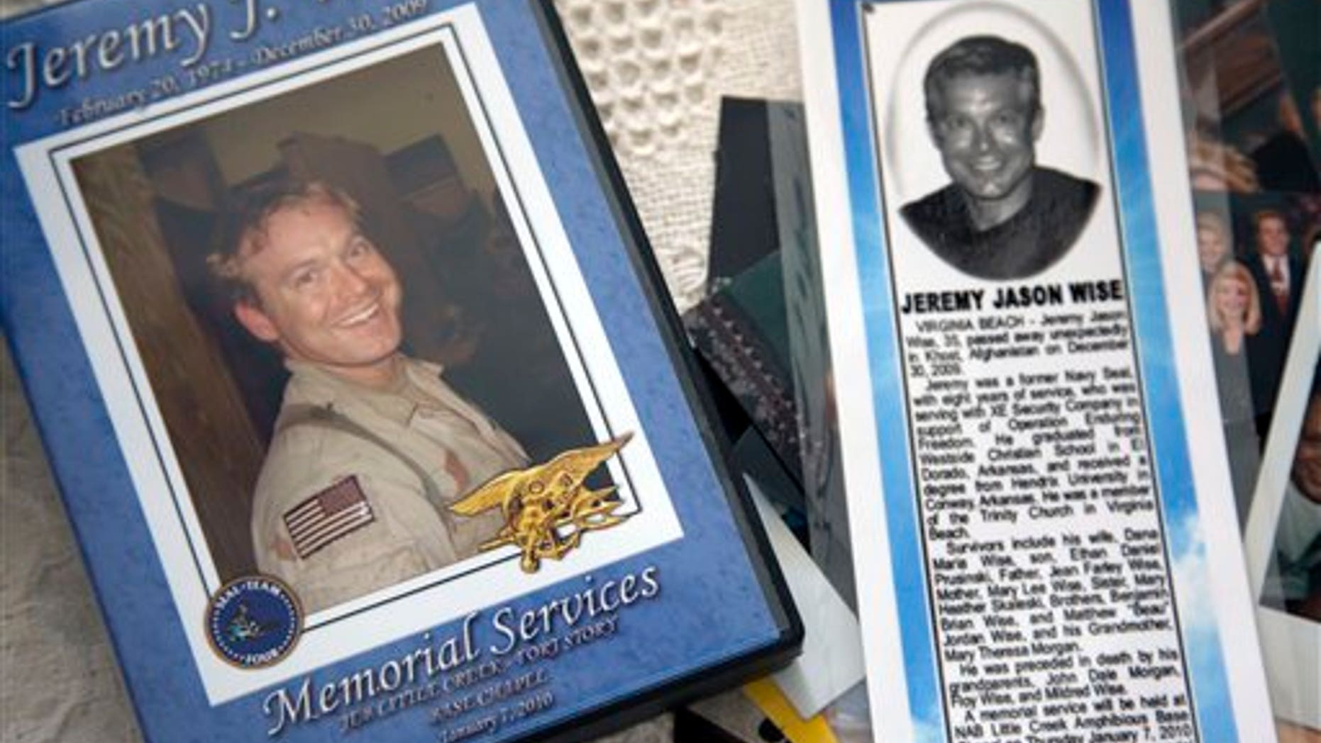 In this photo, taken Jan. 24, 2012, the image of former Navy Seal Jeremy Wise is shown on the cover of a video of his 2009 memorial service and a newspaper obit displayed at his sister's home in Prescott, Ark.