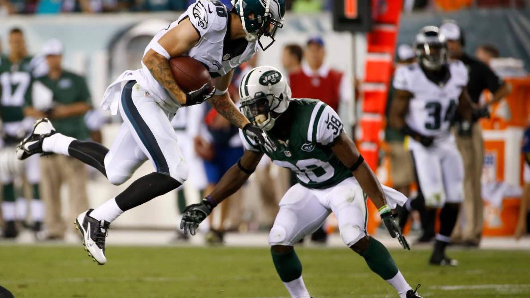 Philadelphia Eagles' Jeff Maehl, left, tries to leap past New York Jets' LeQuan Lewis after catching a pass during the first half of an NFL preseason football game, Thursday, Aug. 28, 2014, in Philadelphia. (AP Photo/Michael Perez)