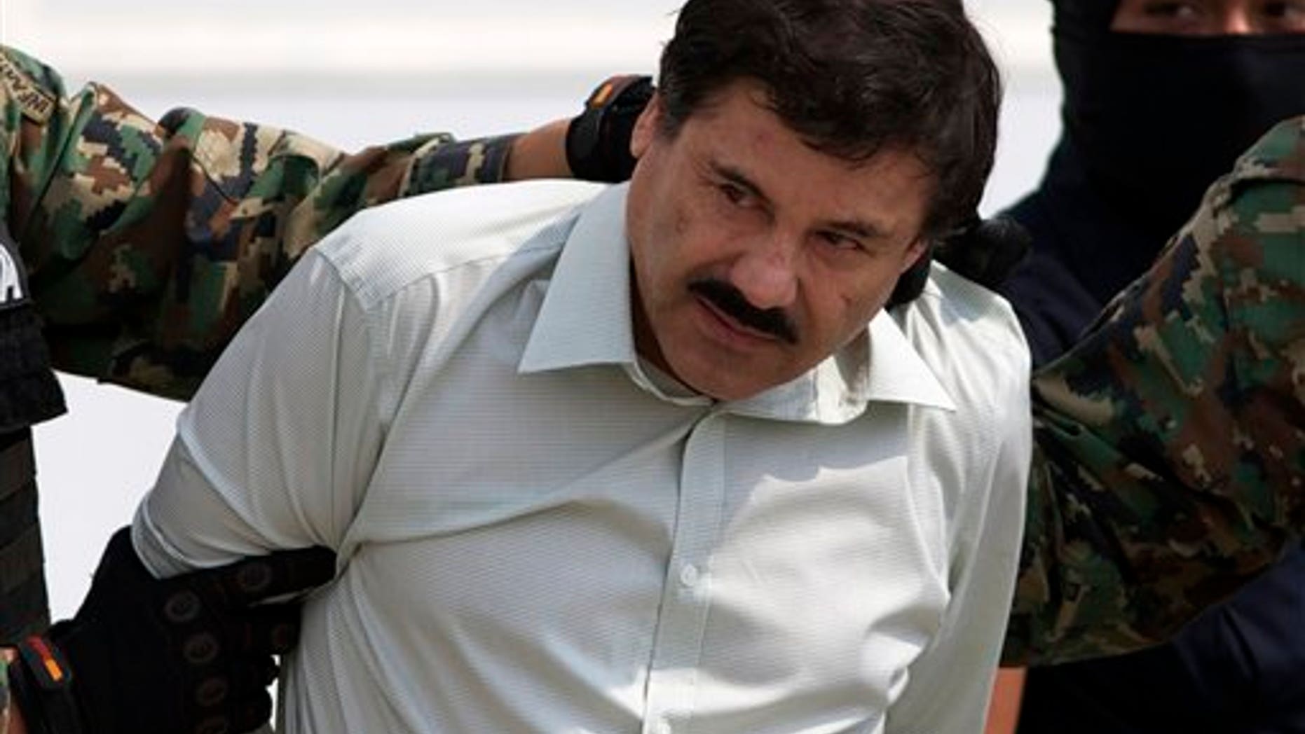 Joaquin "El Chapo" Guzman is escorted to a helicopter in handcuffs by Mexican navy marines at a navy hanger in Mexico City, Saturday, Feb. 22, 2014. A senior U.S. law enforcement official said Saturday, that Guzman, the head of Mexicoís Sinaloa Cartel, was captured alive overnight in the beach resort town of Mazatlan. Guzman faces multiple federal drug trafficking indictments in the U.S. and is on the Drug Enforcement Administrationís most-wanted list. (AP Photo/Eduardo Verdugo)