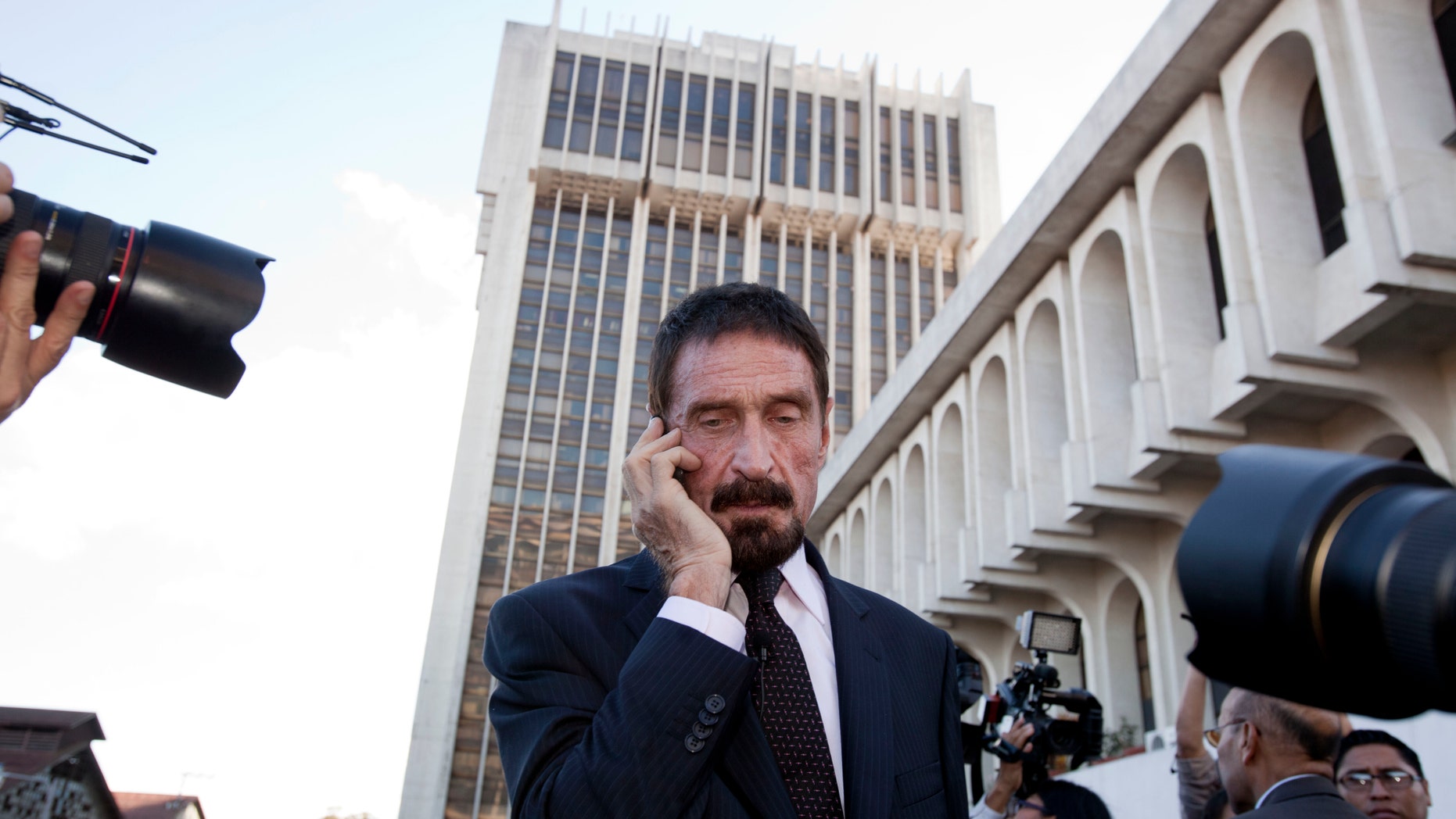 Dec. 4, 2012: Software company founder John McAfee talks on his mobile phone after a press conference outside the Supreme Court in Guatemala City.