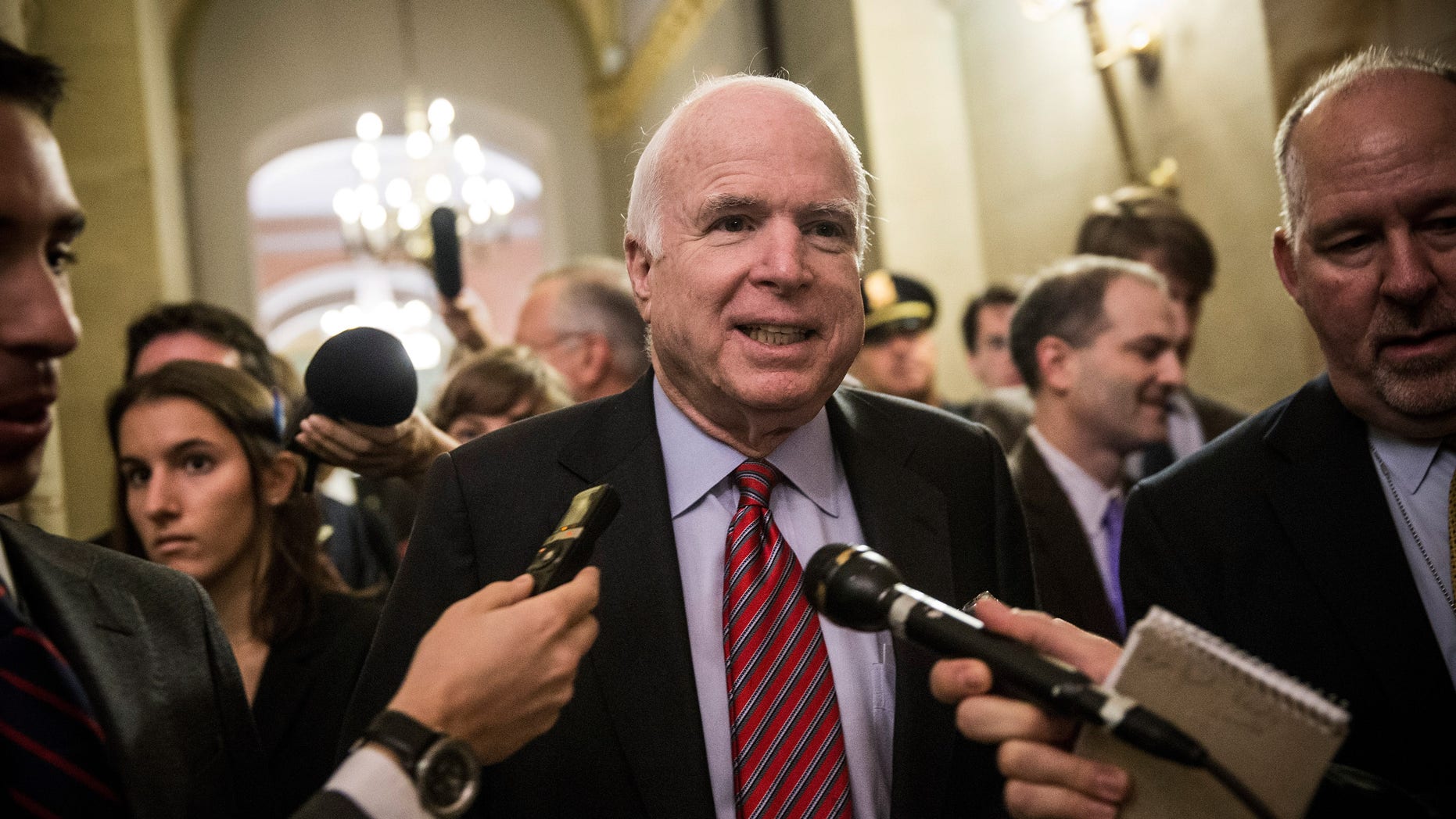 WASHINGTON, DC - OCTOBER 16: Sen. John McCain (R-AZ) answers questions as he arrives for a meeting of Senate Republicans on a solution for the pending budget and debt limit impasse at the U.S. Capitol October 16, 2013 in Washington, DC. The U.S. government shutdown is in its sixteenth day as the U.S. Senate and House of Representatives remain gridlocked on funding the federal government and the extending the nation's debt limit. (Photo by Andrew Burton/Getty Images)