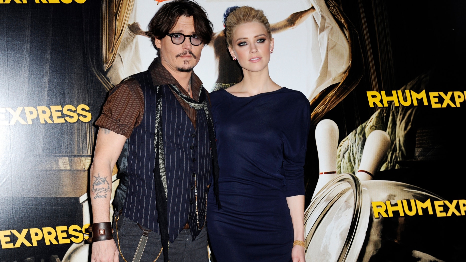 Johnny Depp and Amber Heard pose for photographers as they arrive for the premiere of the film "The Rum Diary" in Paris November 8, 2011