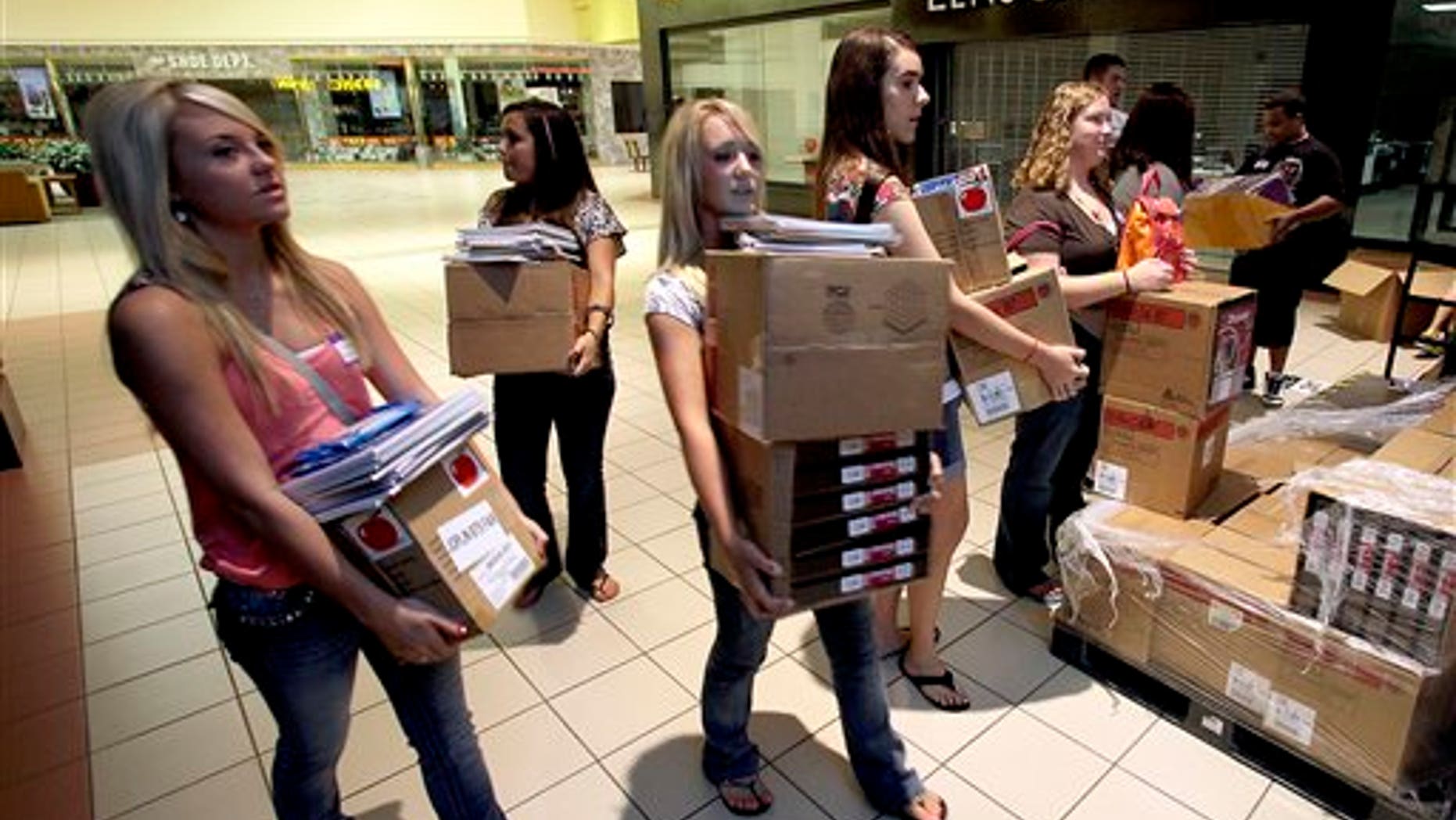 August 17: Students in a cadet teaching class carry donated school supplies to a classroom on the first day of school at a temporary high school in a converted big-box store in Joplin, Mo.