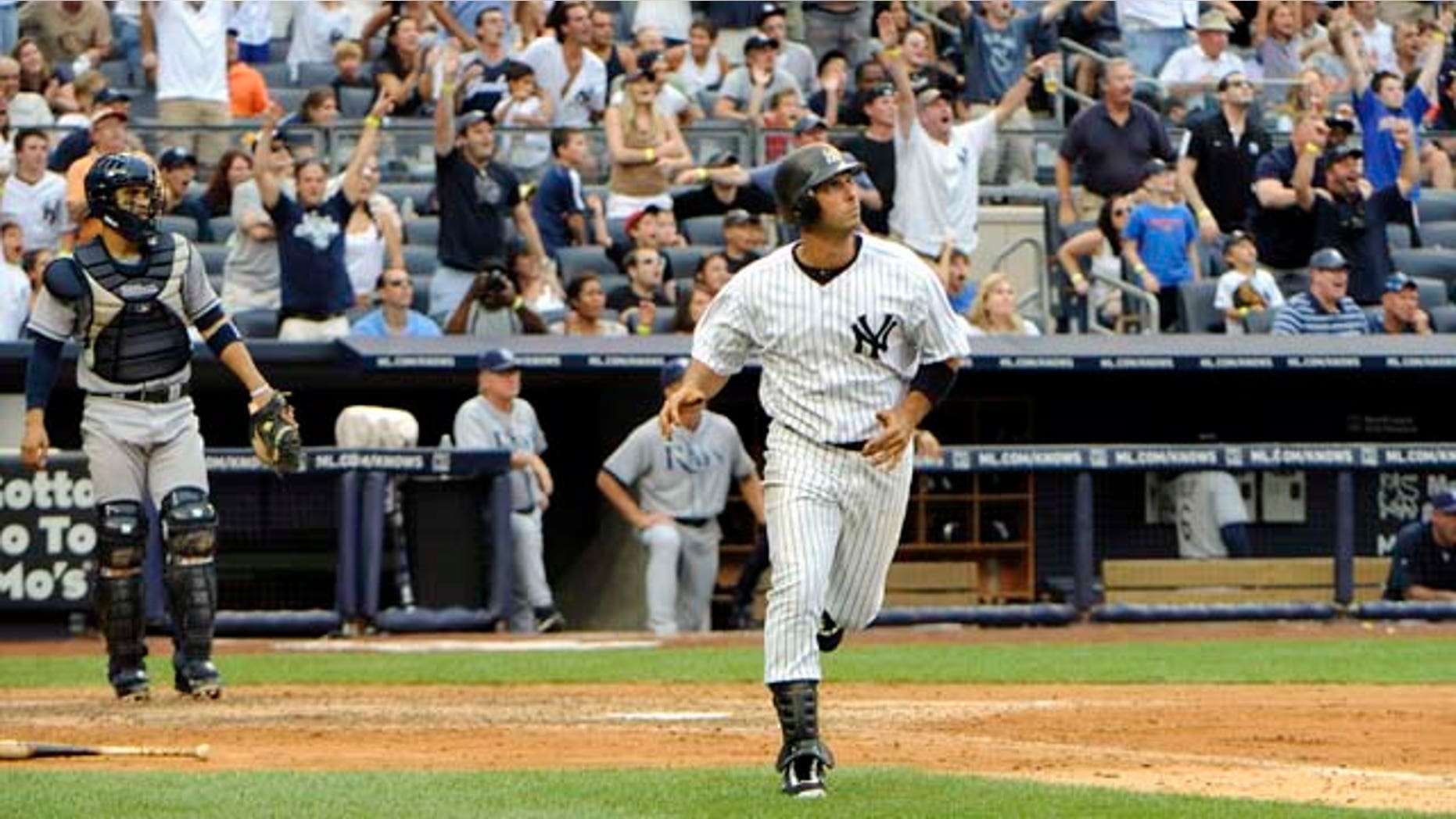 New York Yankees' Jorge Posdada, center, watches his grand slam during the fifth inning of a baseball game against the Tampa Bay Rays, Saturday, Aug. 13, 2011, at Yankee Stadium in New York. (AP Photo/Bill Kostroun)