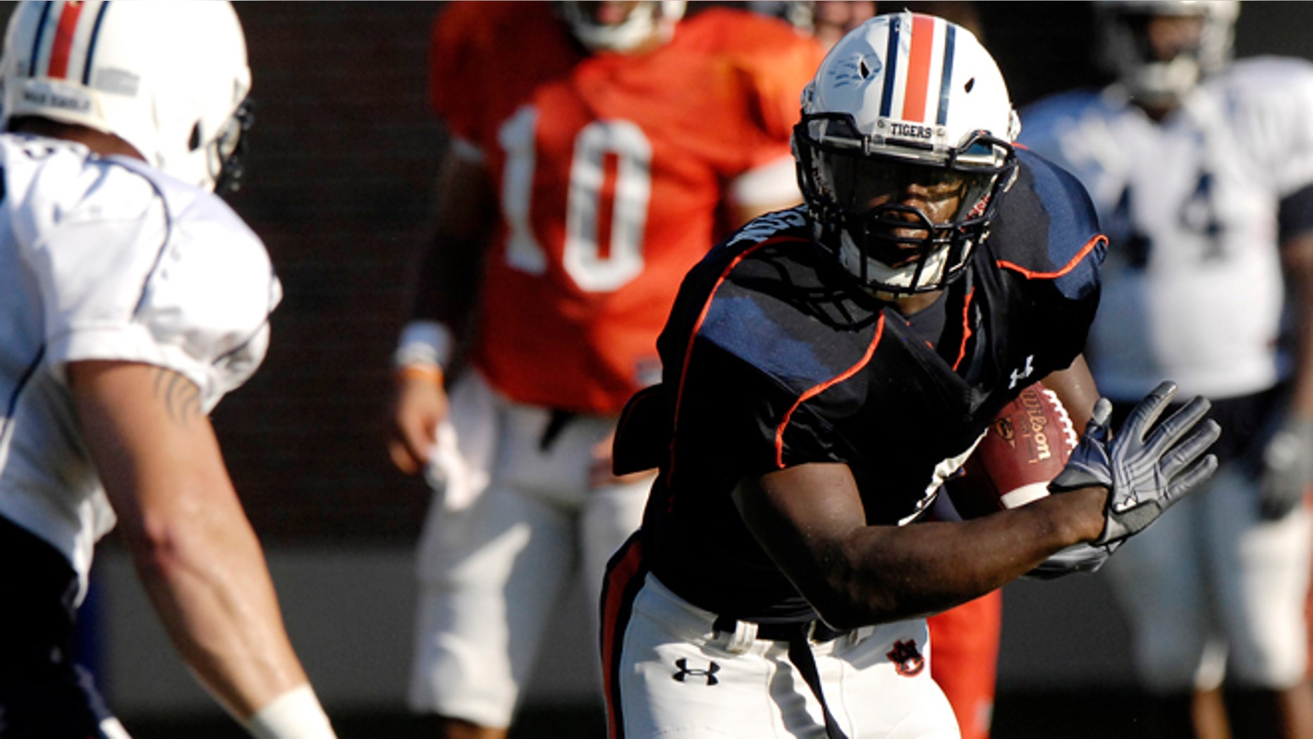 Aug. 6, 2012: Auburn running back Jovon Robinson is tackled by defender Jake Holland during NCAA college football practice on in Auburn, Ala.