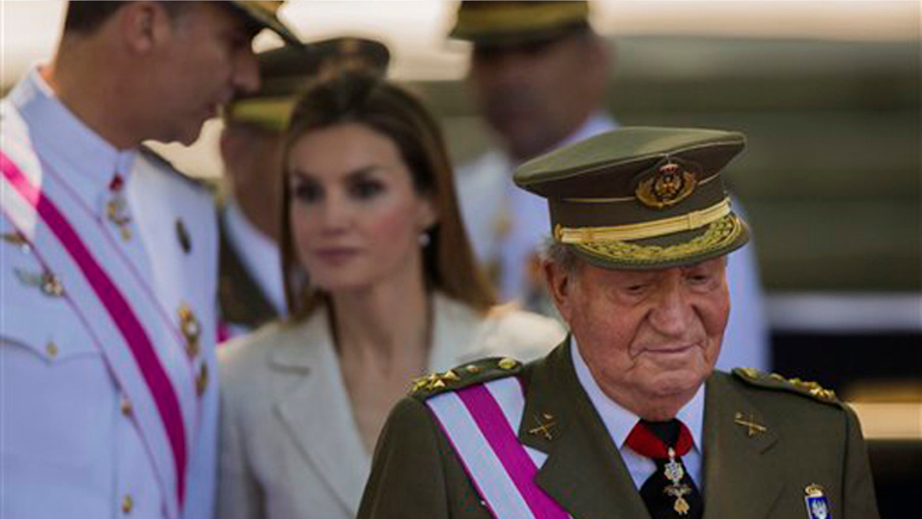 Spanish Crown Prince Felipe, background left, talks with Spanish Princess Letizia, as Spanish King Juan Carlos, foreground looks on, during a military parade on Armed Forces day in Madrid, Spain, Sunday, June 8, 2014. King Juan Carlos plans to abdicate and pave the way for his son, Crown Prince Felipe, to become the country's next king. The 76-year-old Juan Carlos oversaw his country's transition from dictatorship to democracy but has had repeated health problems in recent years. His popularity also dipped following royal scandals, including an elephant-shooting trip he took in the middle of Spain's financial crisis that tarnished the monarch's image. The king came to power in 1975, two days after the death of longtime dictator Francisco Franco. (AP Photo/Andres Kudacki)