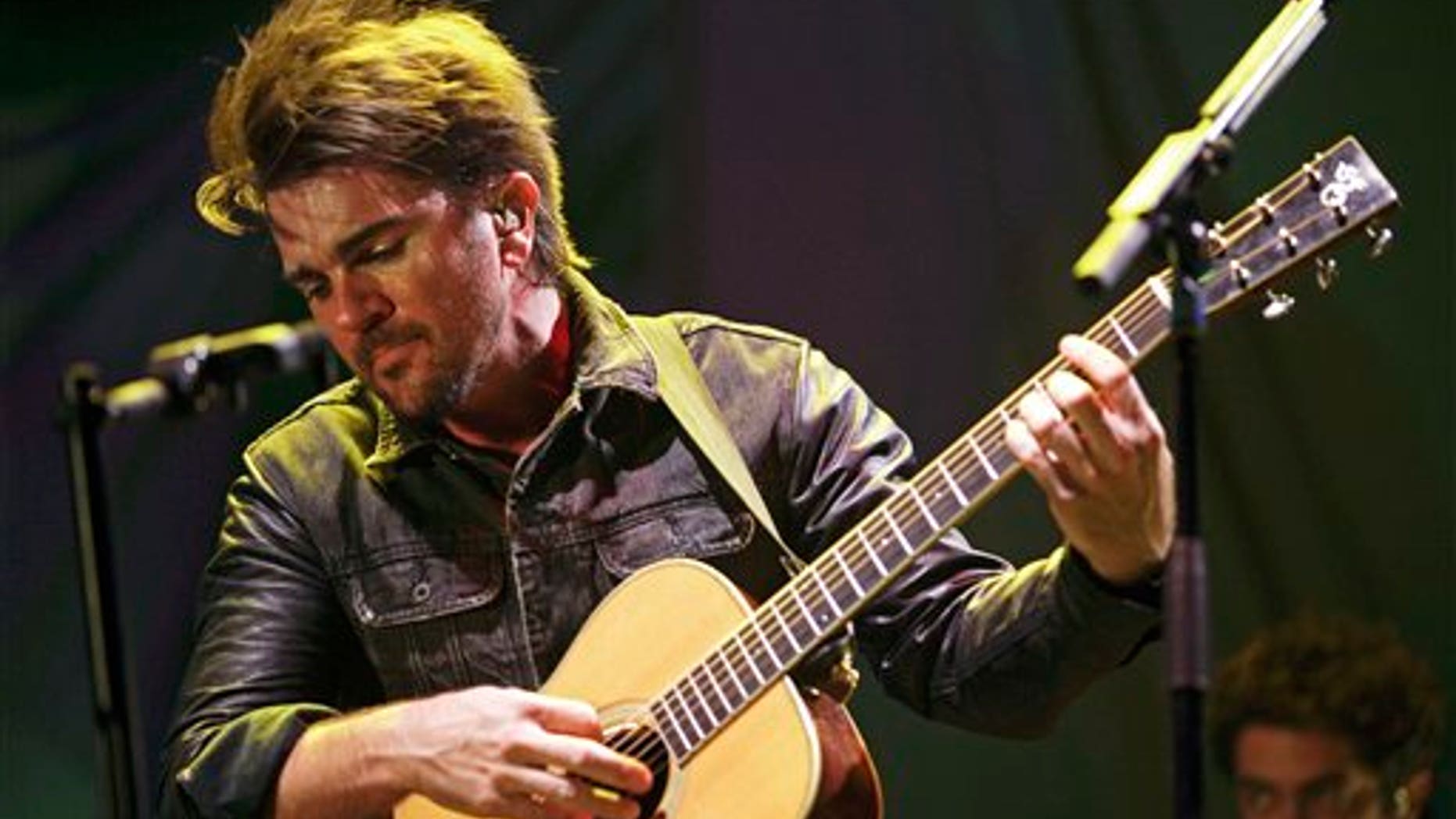 FILE - In this April 18, 2013 file photo, Colombian singer Juanes performs in a concert as a part of his Unplugged tour in Panama City. Juanes will launch his album Loco de Amor, on March 11, 2014. The singer said that the album recorded in live studio sessions at a studio and produced by Steve Lillywhite, is his best work to date. (AP Photo/Arnulfo Franco, File)