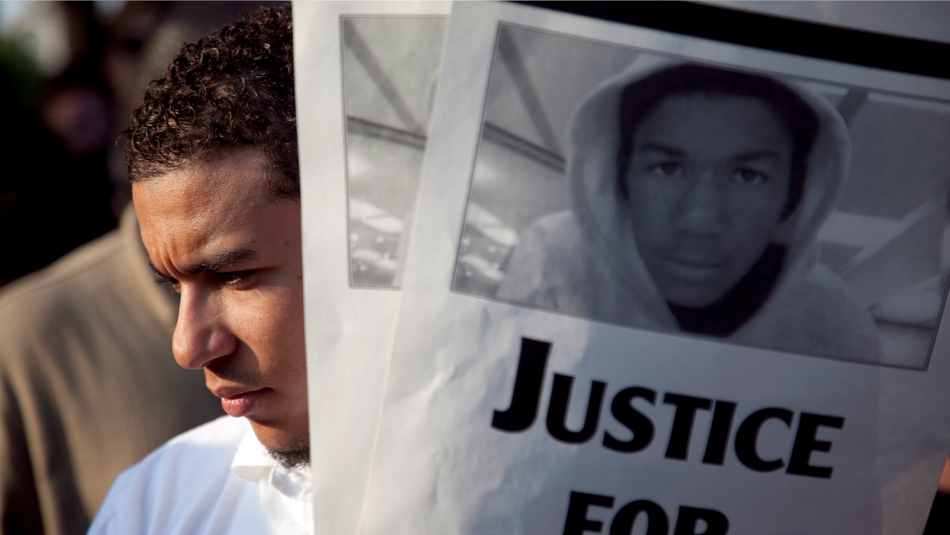 A protestor holds flyers during a rally outside the Texas State Capitol in Austin on Tuesday depicting Travyon Martin, the unarmed Florida teen killed last month. The case has become a racial flashpoint that has civil rights leaders and others leading protests in Florida and around the country. (AP Photo/Thomas Allison, Daily Texan)
