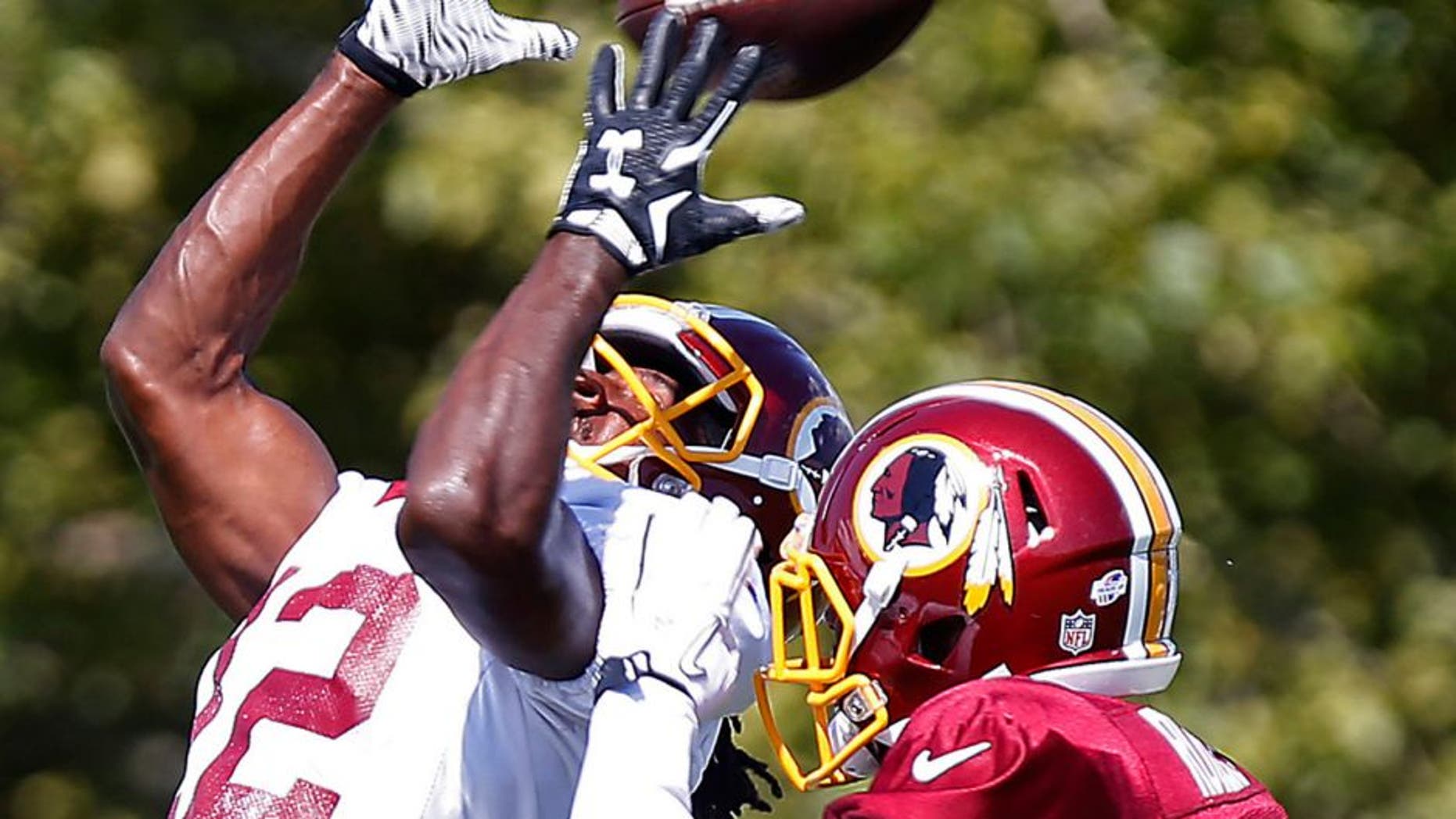 Aug 1, 2015; Richmond, VA, USA; Washington Redskins wide receiver Andre Roberts (12) catches the ball as defensive back Justin Rogers (25) defends during afternoon practice as part of day three of training camp at Bon Secours Washington Redskins Training Center. Mandatory Credit: Geoff Burke-USA TODAY Sports