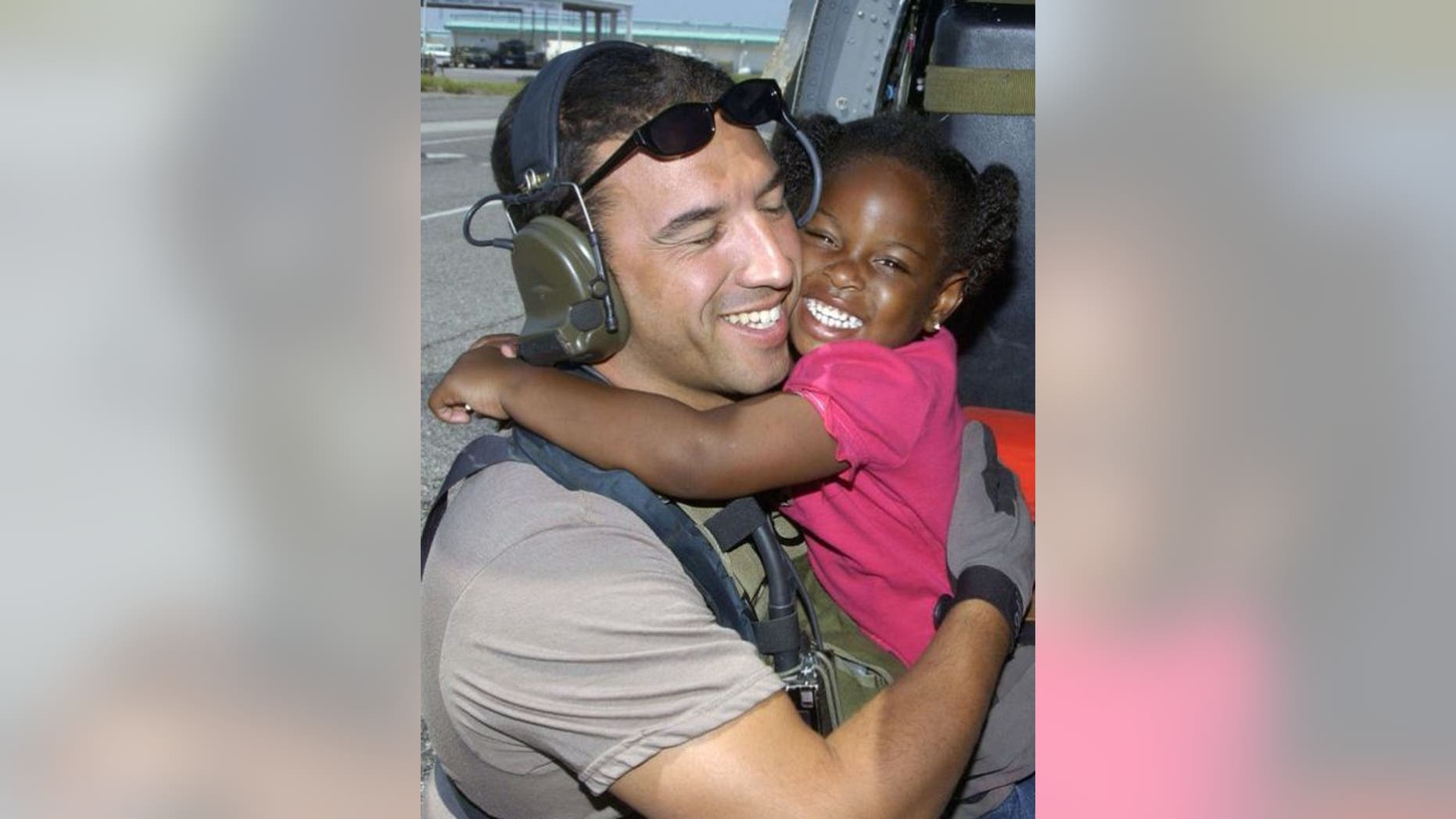 Air Force Reserve Master Sgt. Mike Maroney hugs 3-year-old he rescued in aftermath of Hurricane Katrina in 2005. (Credit: Air Force)