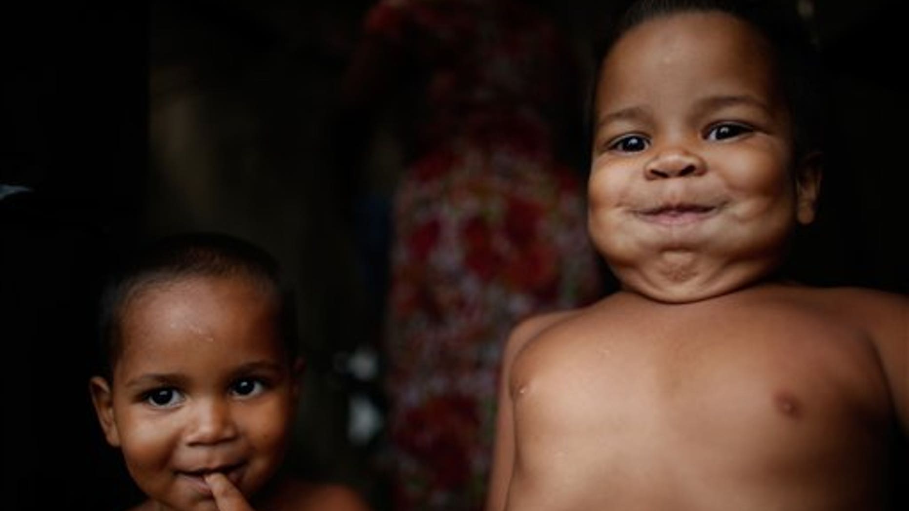 In this Feb. 8, 2015 photo, Miguel, 5, right, and Micael, 2, stand in their family's makeshift tent at a Homeless Workers Movement camp in Brasilia, Brazil. (AP Photo/Eraldo Peres)
