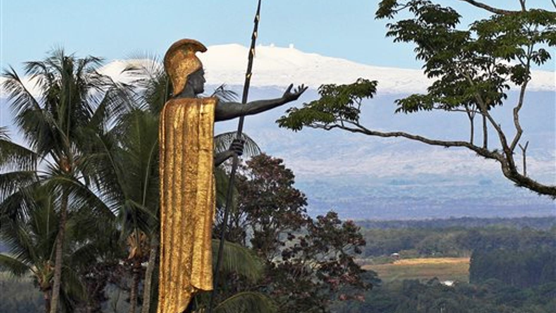 This Jan. 31, 2014, file photo, shows a statue of Hawaiian King Kamehameha I with snow-capped Mauna Kea in the distance, in Hilo, Hawaii. Part of Kamehameha's spear is missing.