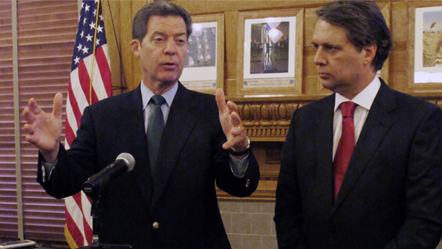FILE - In this Sept. 11, 2014 file photograph, Kansas Gov. Sam Brownback, left, and Lt. Gov. Jeff Colyer speak at the Statehouse in Topeka. (AP Photo/John Hanna, File)