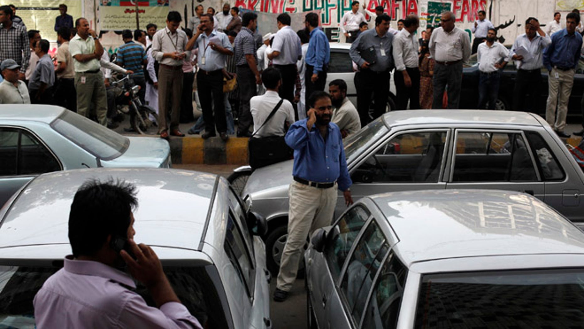 April 16, 2013: Office workers stand outside of their buildings following an earthquake tremor in Karachi. An magnitude 7.8 earthquake struck Iran on Tuesday with tremors felt across Pakistan among other regions, media reported.