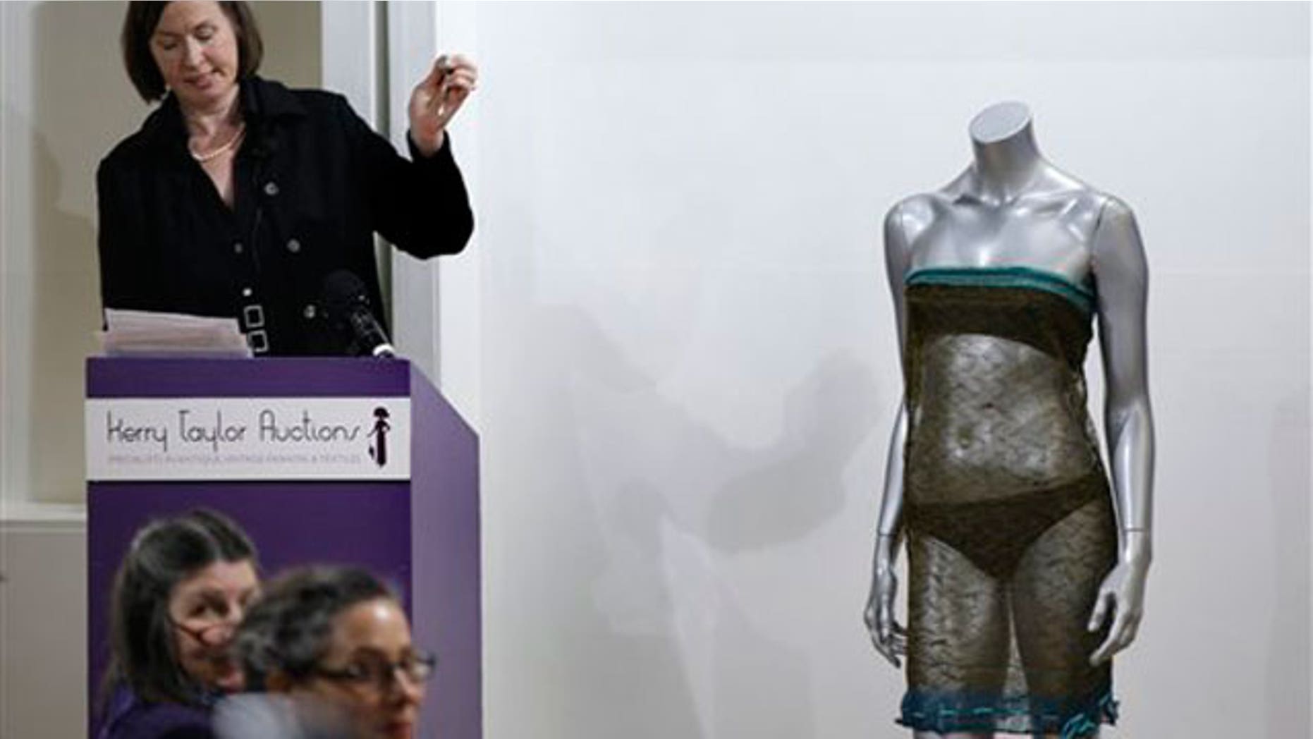 March 17: The auctioneer hammers down to close the sale of the see-through knitted lace dress worn by Kate Middleton on display, right, during the 'Passion for Fashion' auction in central London. (AP)