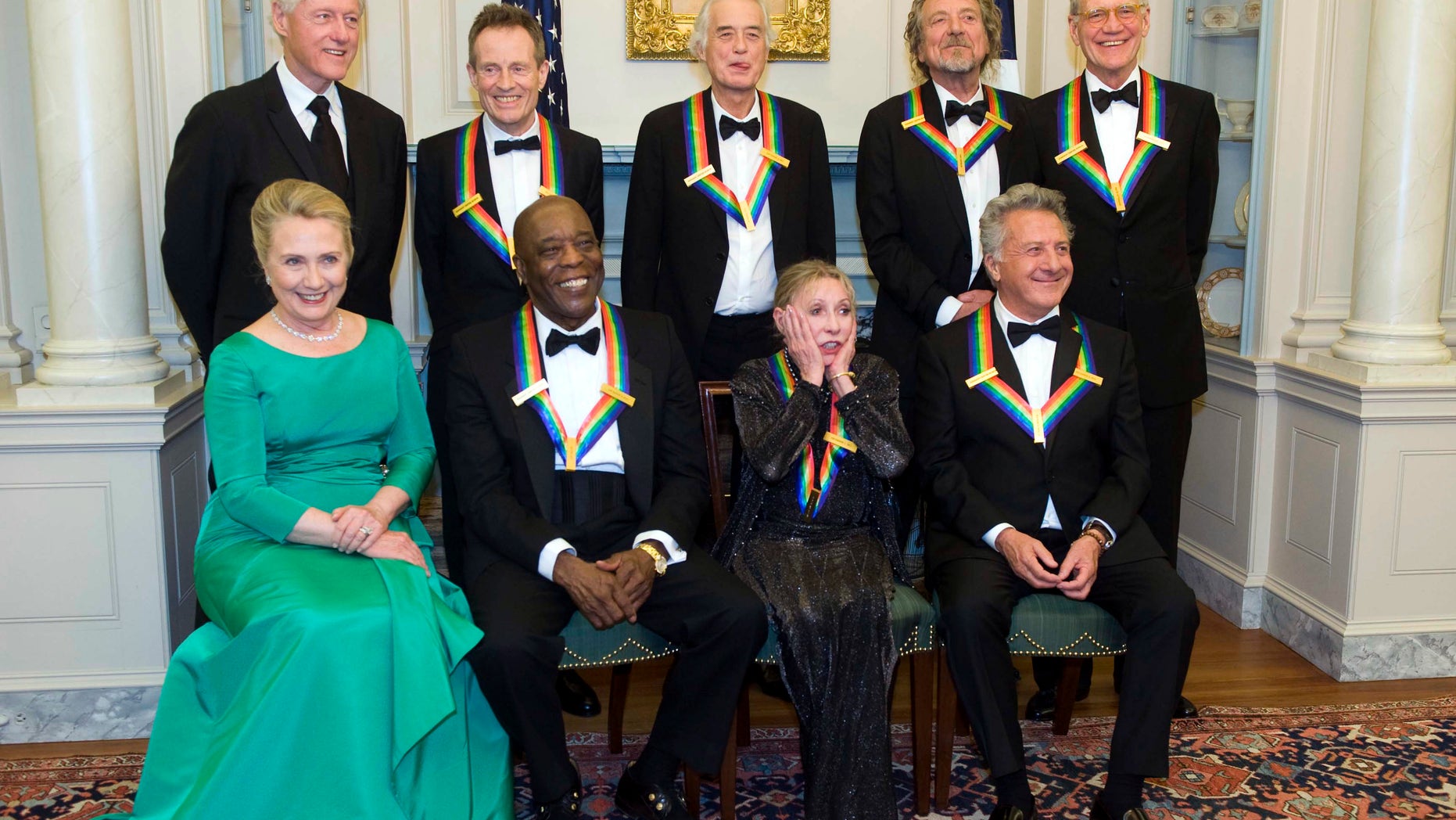 2012 Kennedy Center Honoree Natalia Makarova, front row, second right, reacts to all the photos being taken during a group photo after the State Department Dinner for the Kennedy Center Honors gala Saturday, Dec. 1, 2012 at the State Department in Washington. From left are former President Bill Clinton, Secretary of State Hillary Rodham Clinton, John Paul Johns, Buddy Guy, Jimmy Page, Makarova, Robert Plant, Dustin Hoffman and David Letterman. (AP Photo/Kevin Wolf)