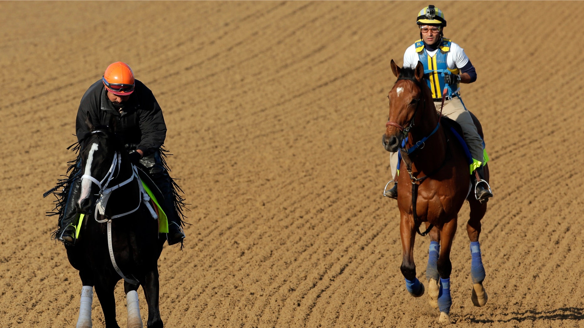 Exercise rider Aurelio Gomez rides Kentucky Derby hopeful Black Onyx, left, and Trainer Rudy Rodriguez rides Vyjack for a workout at Churchill Downs Tuesday, April 30, 2013, in Louisville, Ky. (AP Photo/Charlie Riedel)