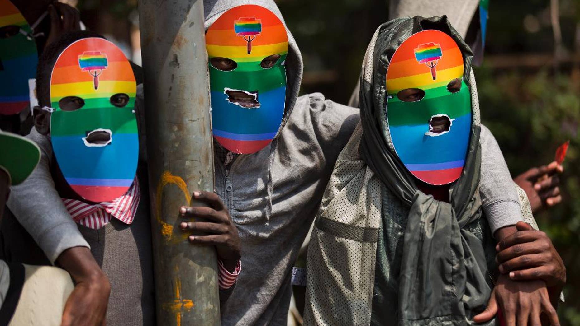 FILE - In this Monday, Feb. 10, 2014 file photo, Kenyan gays and lesbians and others supporting their cause wear masks to preserve their anonymity as they stage a rare protest, against Uganda's tough stance against homosexuality and in solidarity with their counterparts there, outside the Uganda High Commission in Nairobi, Kenya. Kenyan High Court judges on Monday, April 27, 2015 ordered a government agency to register a human rights group representing the country's gay people, a move which had previously been opposed on religious and moral grounds. (AP Photo/Ben Curtis, File)