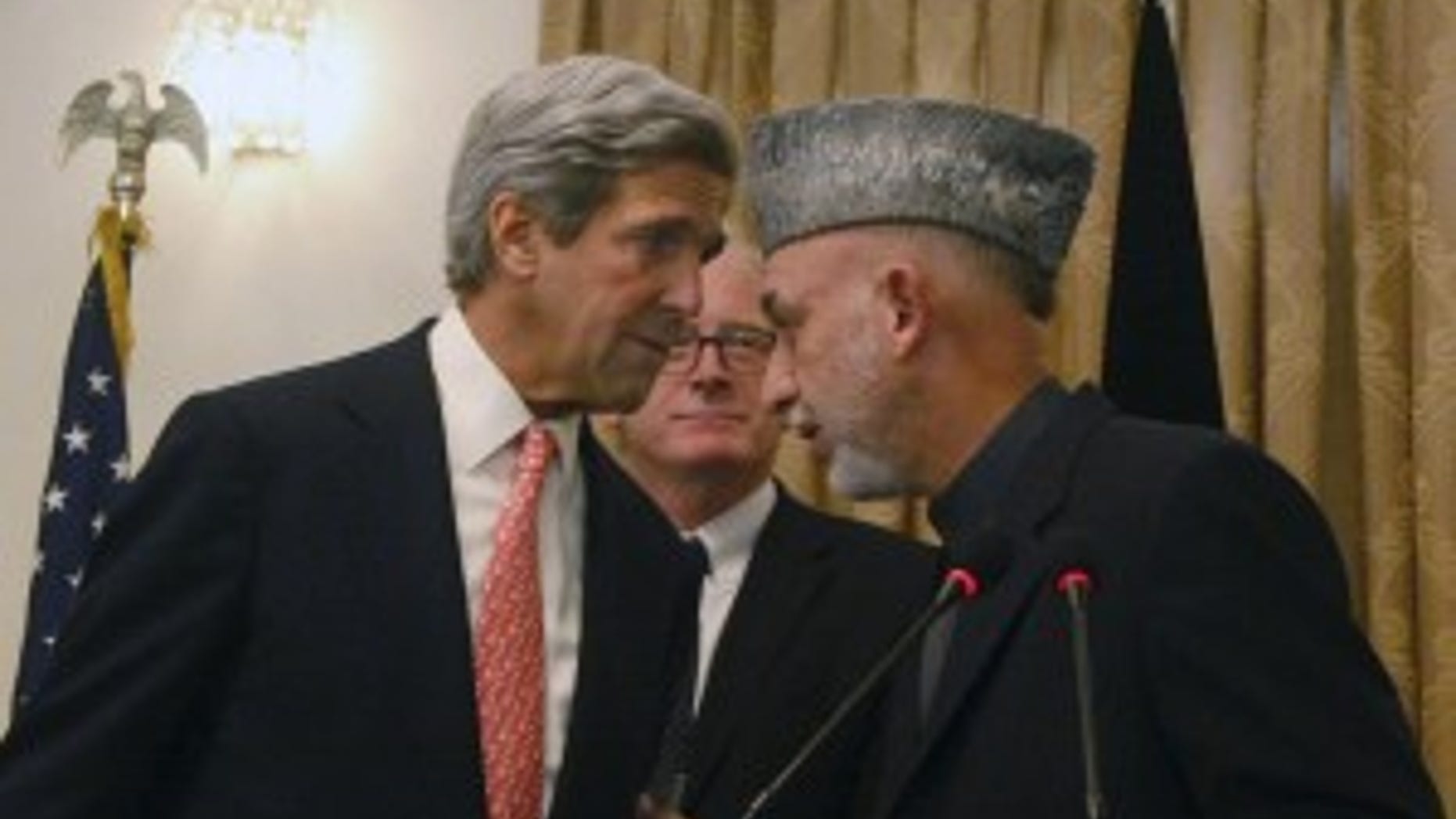 Afghan President Hamid Karzai, right, whispers with the U.S. Sen. John Kerry, D-Mass, left, as Kai Eide head of the United Nations Assistance Mission in Afghanistan is seen, center, during a press conference, in Kabul, Afghanistan on Tuesday, Oct. 20, 2009. Afghanistan's election commission today ordered a Nov. 7 runoff in the disputed presidential poll after a fraud investigation dropped incumbent Hamid Karzai's votes below 50 percent of the total. Karzai accepted the finding and agreed to a second round vote. (AP Photo/Musadeq Sadeq)