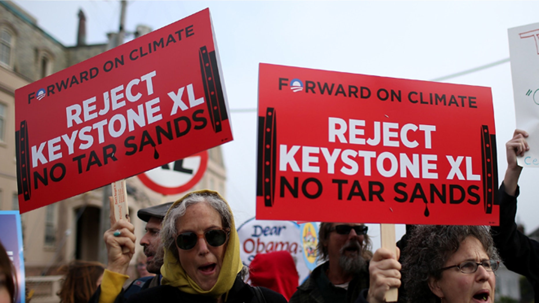 SAN FRANCISCO, CA - APRIL 03: Demonstrators hold signs as they protest near the site of a fundraiser on April 3, 2013 in San Francisco, California. Hundreds of protesters staged a demonstration against war and the Keystone XL pipeline outside of a fundraiser to be attended by U.S. President Barack Obama at the home of Ann and Gordon Getty. (Photo by Justin Sullivan/Getty Images)