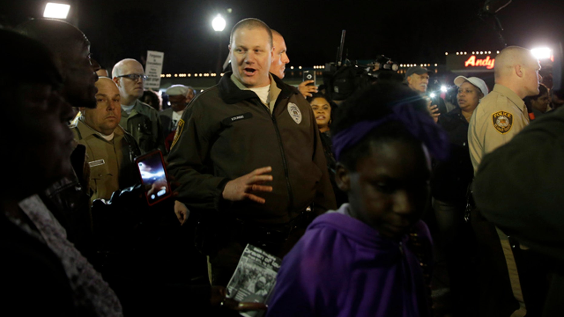 March 12, 2015: Members of the St. Louis County Police Department walk through a crowd of protesters trying to move them out of the street in front of the Ferguson Police Department. (AP Photo/Jeff Roberson)