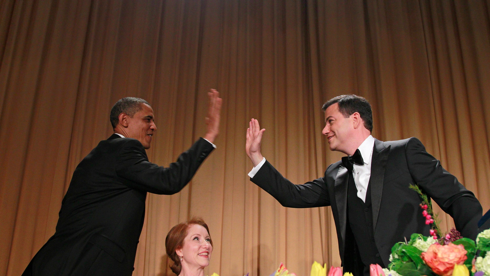 April 28, 2012: President Barack Obama high-fives late-night comic Jimmy Kimmel as Caren Bohan, a Reuters journalist and president of the White House Correspondents' Association looks on during the White House Correspondents' Association Dinner.