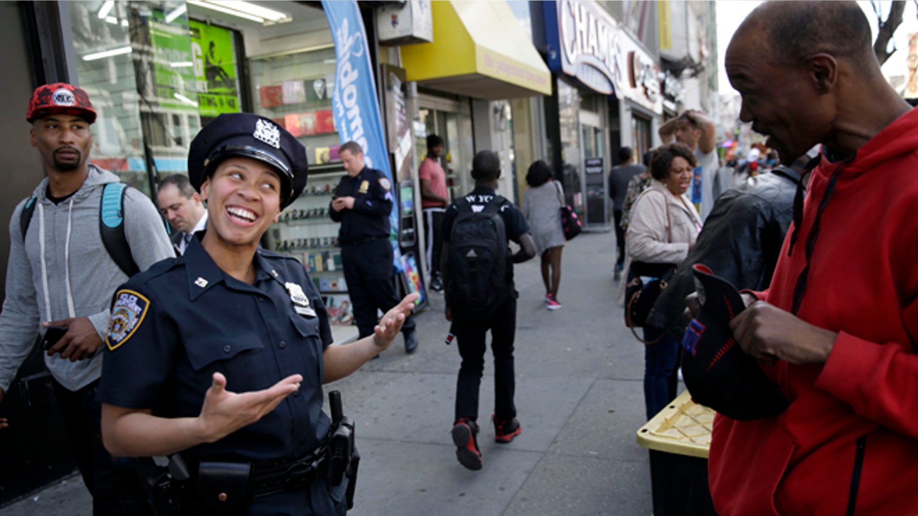 Police officer Lanora Moore talks with a man on 125th Street in the Harlem section of New York, Wednesday, April 29, 2015. (AP Photo/Seth Wenig)