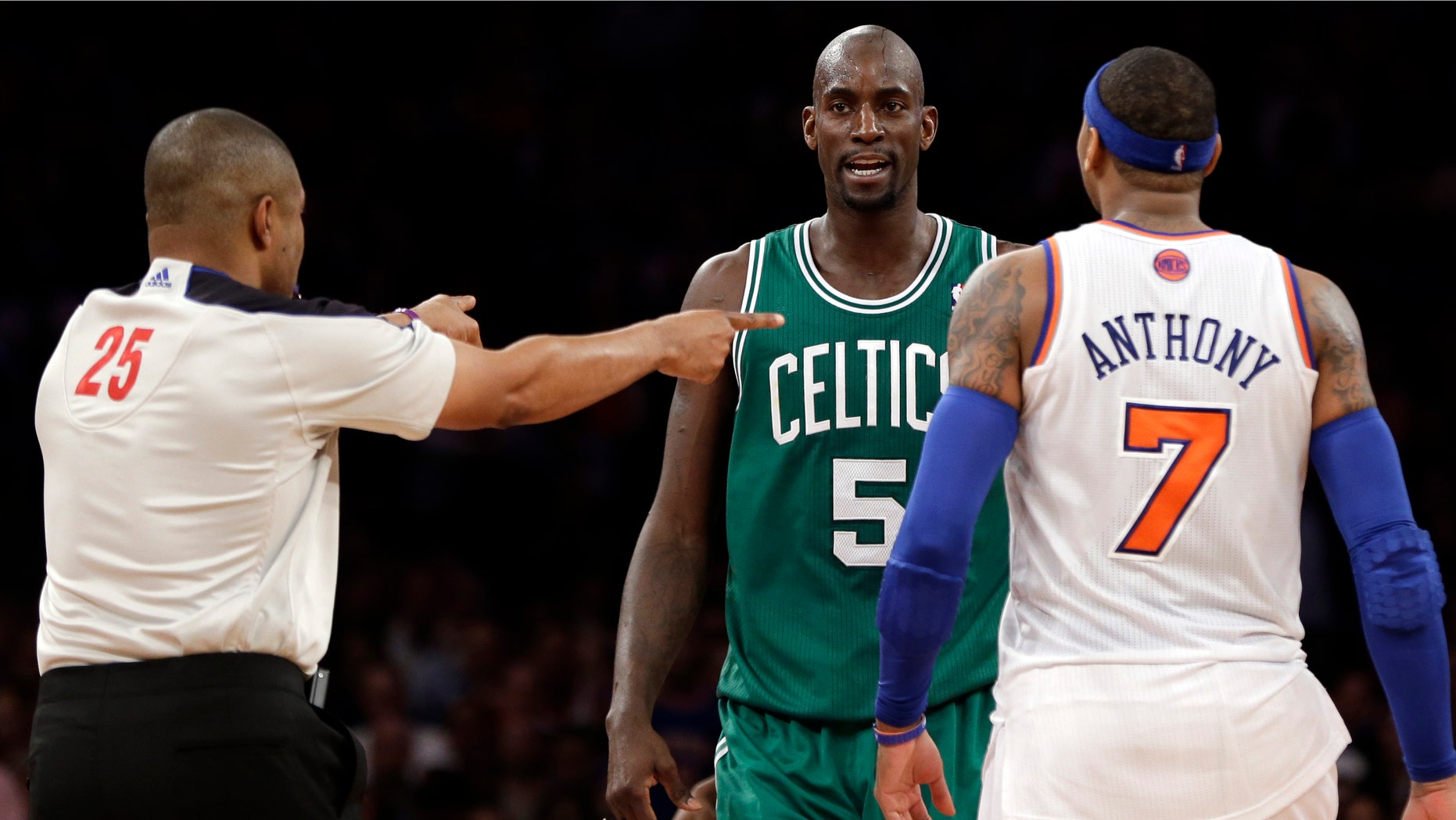 In this photo taken Monday, Jan. 7, 2013, referee Tony Brothers, left, issues technical fouls to New York Knicks' Carmelo Anthony and Boston Celtics' Kevin Garnett during the second half of an NBA basketball game at Madison Square Garden in New York. The All-Star forwards exchanged words during the game and Anthony clearly was affected. He said Tuesday he lost his cool after Garnett said things to him that he feels shouldn't be said to "another man." (AP Photo/Kathy Willens)