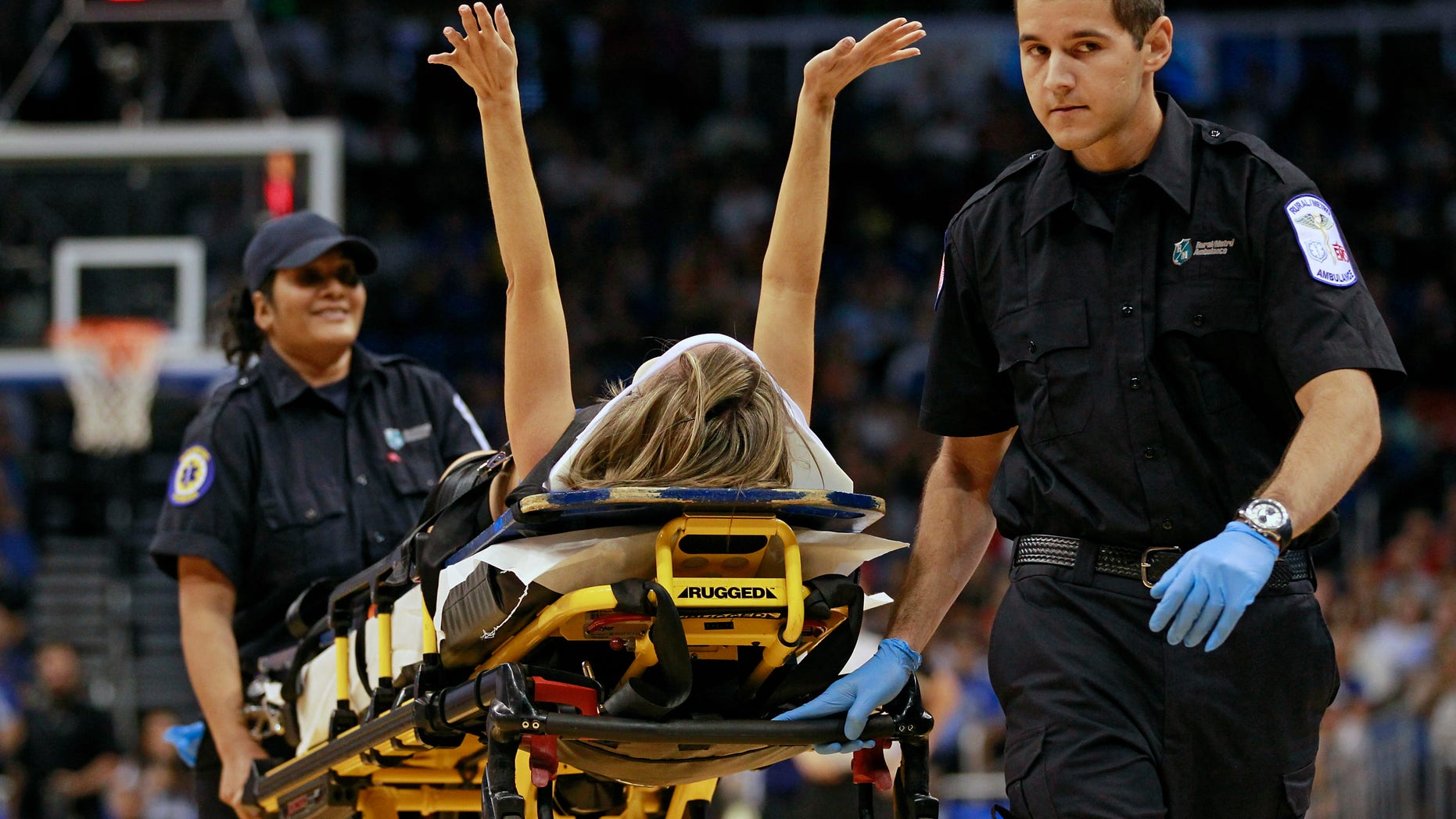 Nov. 13, 2012: Jamie Woode, a former college cheerleader and Magic Stunt Team member, fell during a routine and is wheeled off the floor on a stretcher as she waves her arms to fans during the first half of an NBA basketball game between the Orlando Magic and the New York Knicks in Orlando, Fla.