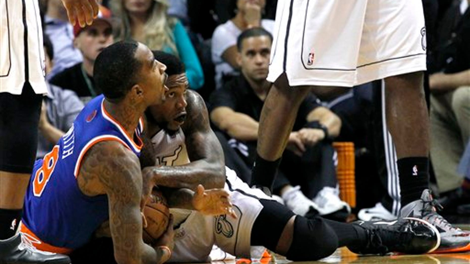 New York Knicks' J.R. Smith (8) battles Miami Heat's Udonis Haslem (40) for control of the loose ball during the first half of an NBA basketball game, Thursday, Dec, 6, 2012, in Miami.