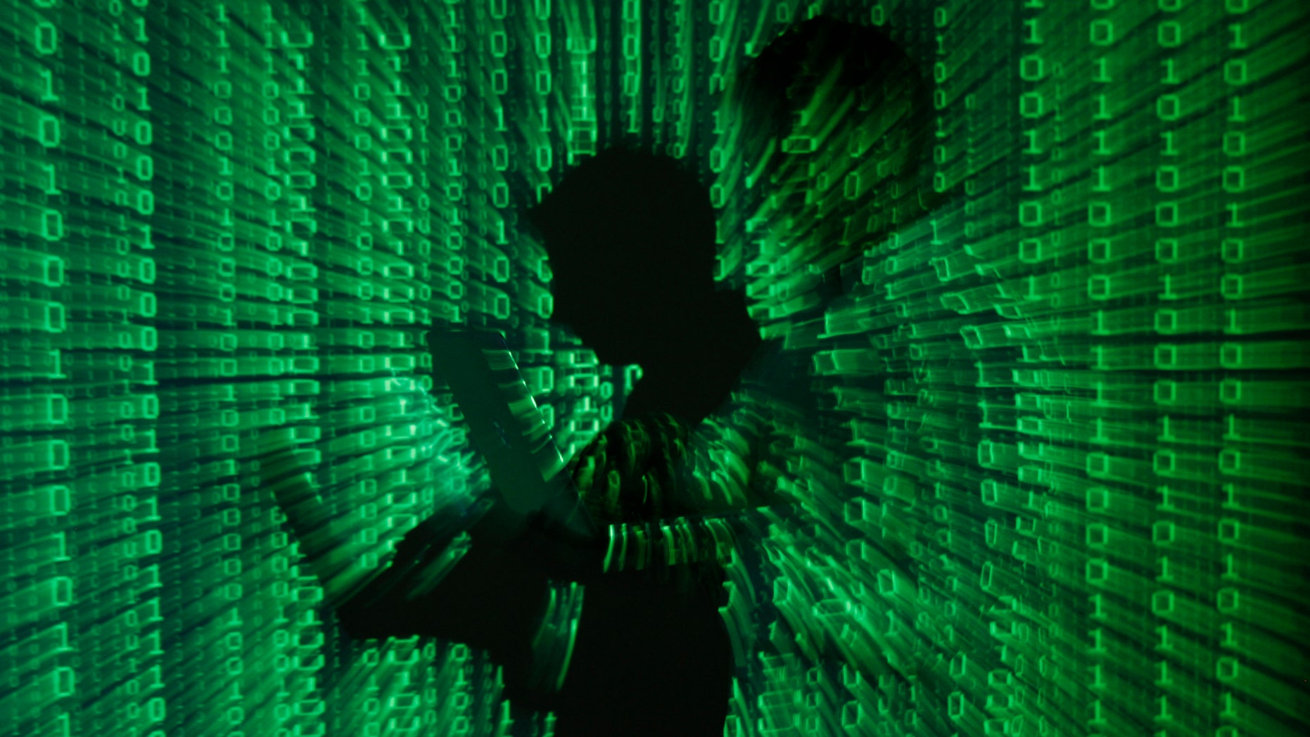 An illustration picture shows a projection of binary code on a man holding a laptop computer, in an office in Warsaw June 24, 2013. REUTERS/Kacper Pempel (POLAND - Tags: BUSINESS TELECOMS TPX IMAGES OF THE DAY) - RTX10ZB5