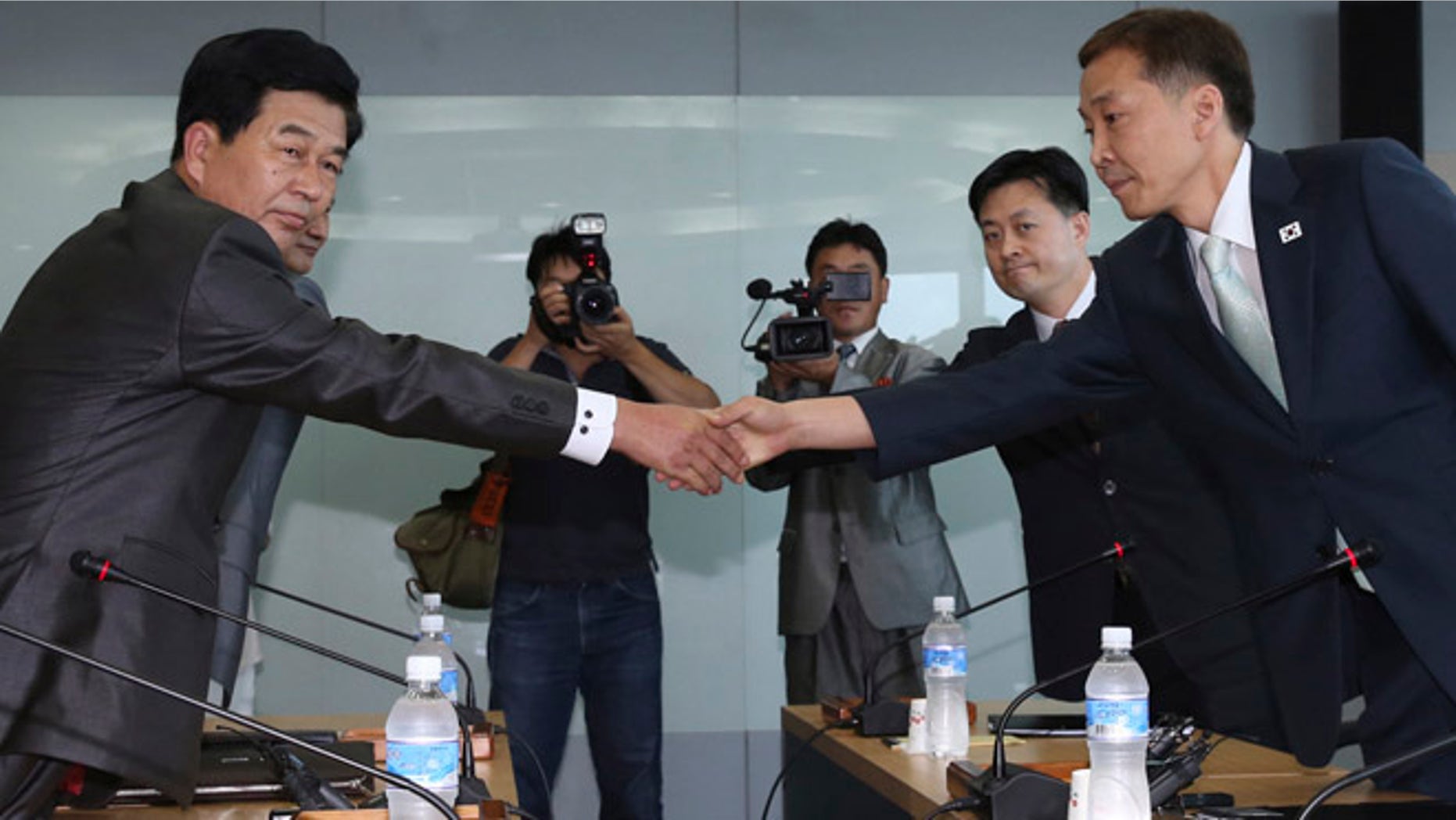 Aug. 14, 2013: Kim Kiwoong, right, the head of South Korea's working-level delegation, shakes hands with his North Korean counterpart Park Chol Su, left, before their meeting at Kaesong Industrial District Management Committee in Kaesong, North Korea.