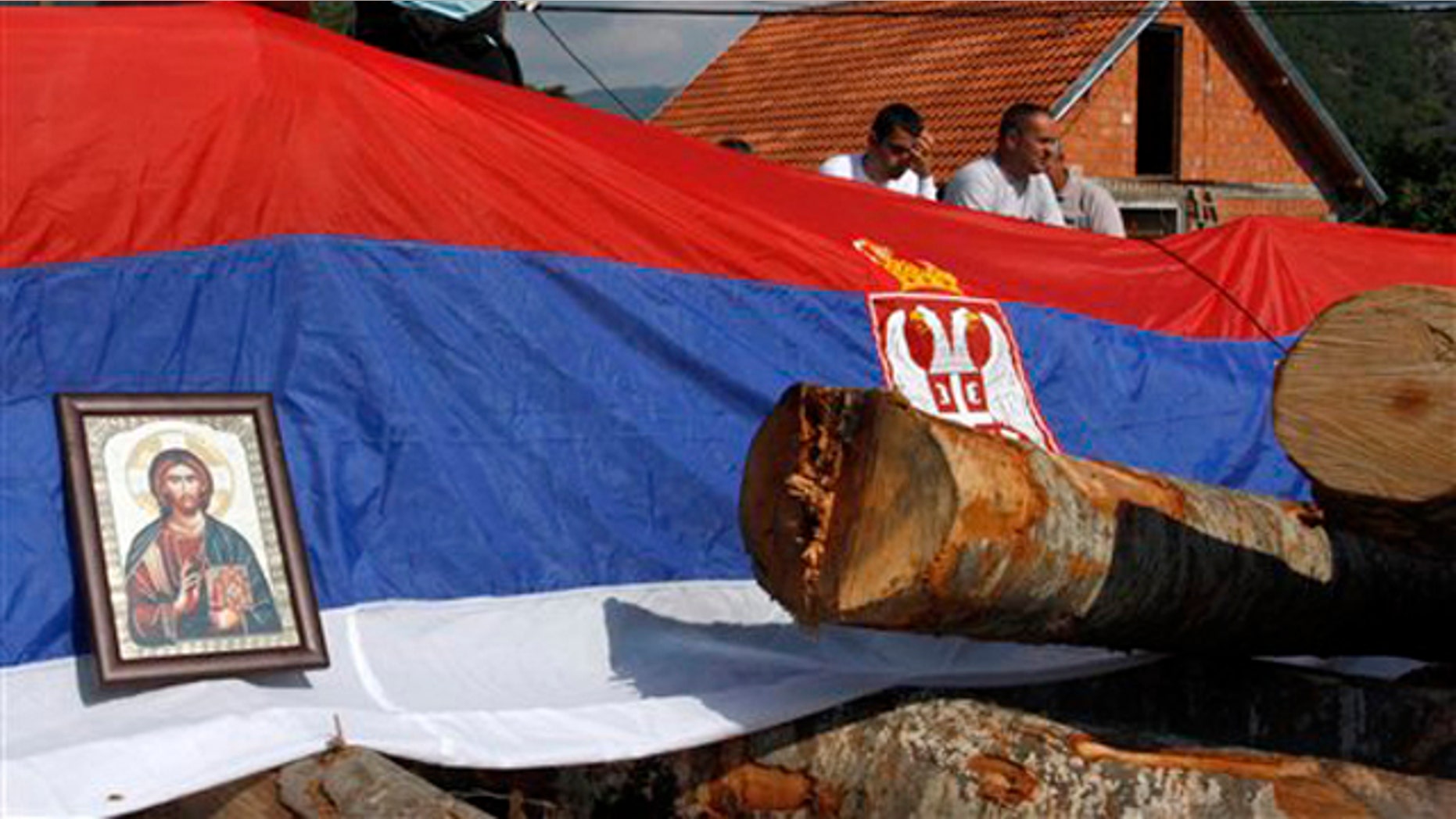 An icon and Serbian flag cover a barricade on the road near the village of Zupce, northern Kosovo, Monday, Aug. 1, 2011. A NATO spokesman in Kosovo says the military alliance has started removing roadblocks put up by Serbs in the country's north during a week of violence that left one Kosovo policeman dead.