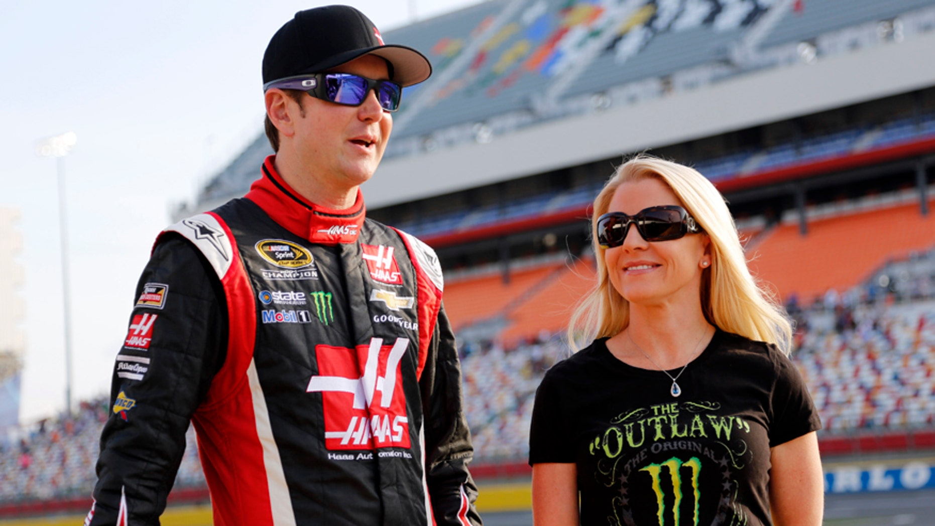 FILE - In this May 22, 2014, file photo, Kurt Busch, left, walks with Patricia Driscoll before qualifying for a NASCAR Sprint Cup series auto race at Charlotte Motor Speedway in Concord, N.C. The police investigation into allegations that NASCAR driver Kurt Busch assaulted his ex-girlfriend has been finished and forwarded to Delaware state prosecutors to decide whether charges will be filed. Cpl. Mark Hoffman with the Dover Police Department said Tuesday, Jan. 6, 2015, that the agency's investigation into the allegations was finished, but he declined to say whether investigators were recommending that Busch be charged. (AP Photo/Terry Renna)
