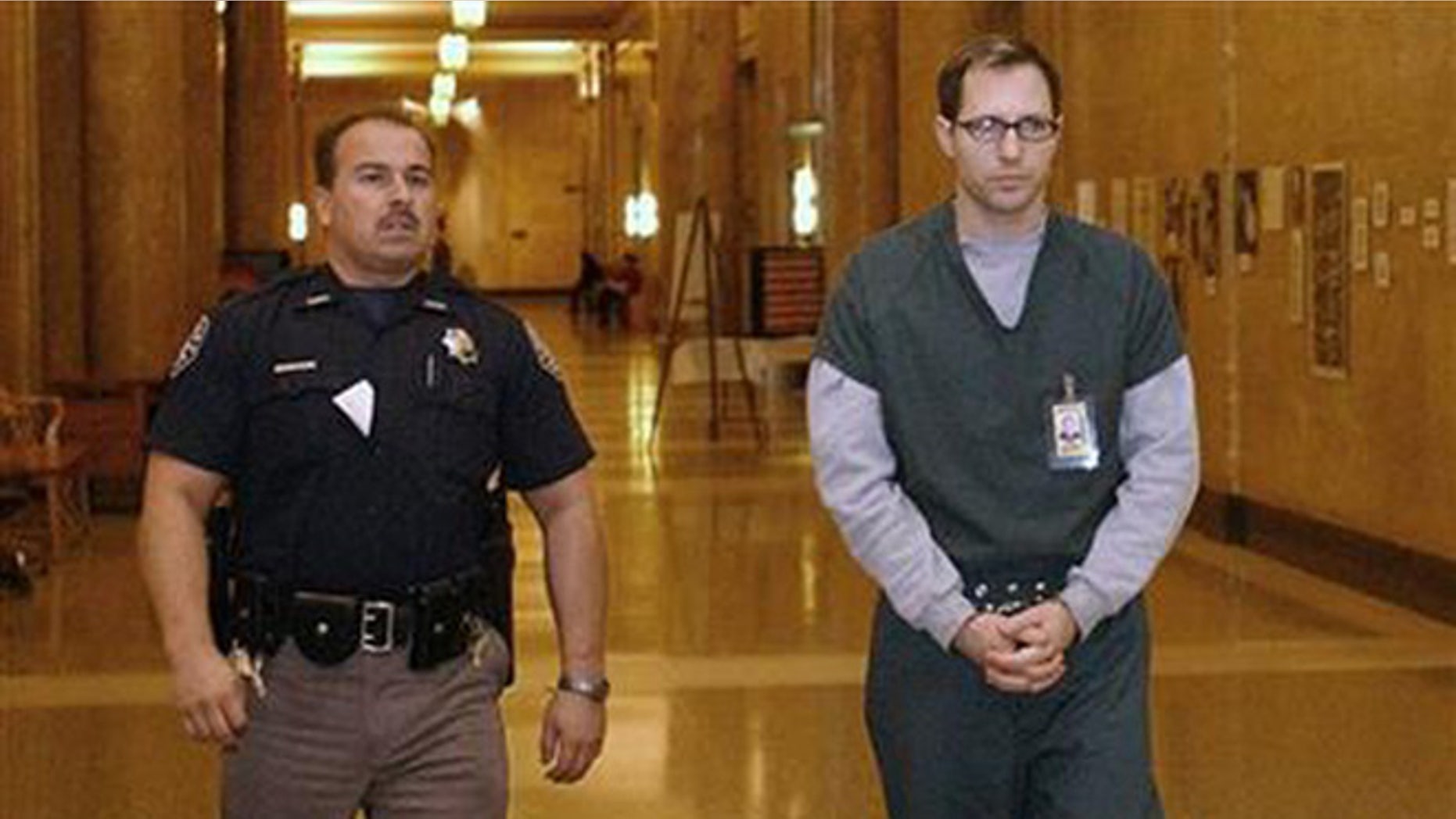 In this Feb. 21, 2002 file photo, Kurt Sonnenfeld, right, is led in handcuffs to a court for an appearance to face a first-degree murder charge in the death of his wife Nancy Sonnenfeld, in Denver, Colorado. On Dec. 11, 2104, Argentina's Supreme Court ruled that Sonnenfeld, who took refuge in the South American country in 2003, can be extradited to the U.S. to face charges that he killed his wife. Sonnenfeld had been a cameraman for the Federal Emergency Management Agency at the World Trade Center after the Sept. 11, 2001, terrorist attacks and claimed he had video footage indicating the government knew the attacks would happen. He claimed that his wife, who was found dead in their home on Jan. 1, 2002, had killed herself and that prosecutors framed him for her death to silence him, allegations that Denver's district attorney's office has denied. (AP Photo/The Denver Post, John Prieto, File)
