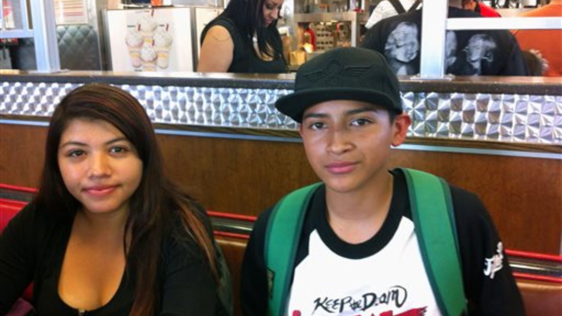 This Oct. 1, 2013 photo showing Roosevelt High School students Carlos Espinoza and Maria Aguilera talk during an interview in Los Angeles. They were among two of the Los Angeles Unified School District's 650,000 students to receive iPads under a district plan to supply every student and teacher with one of the tablets by next year. Espinoza says he quickly cracked the iPad's security settings and used it to go on Facebook. Aguilera says district officials shouldn't have been surprised that hundreds of high school students would do that. (AP Photo/John Rogers)