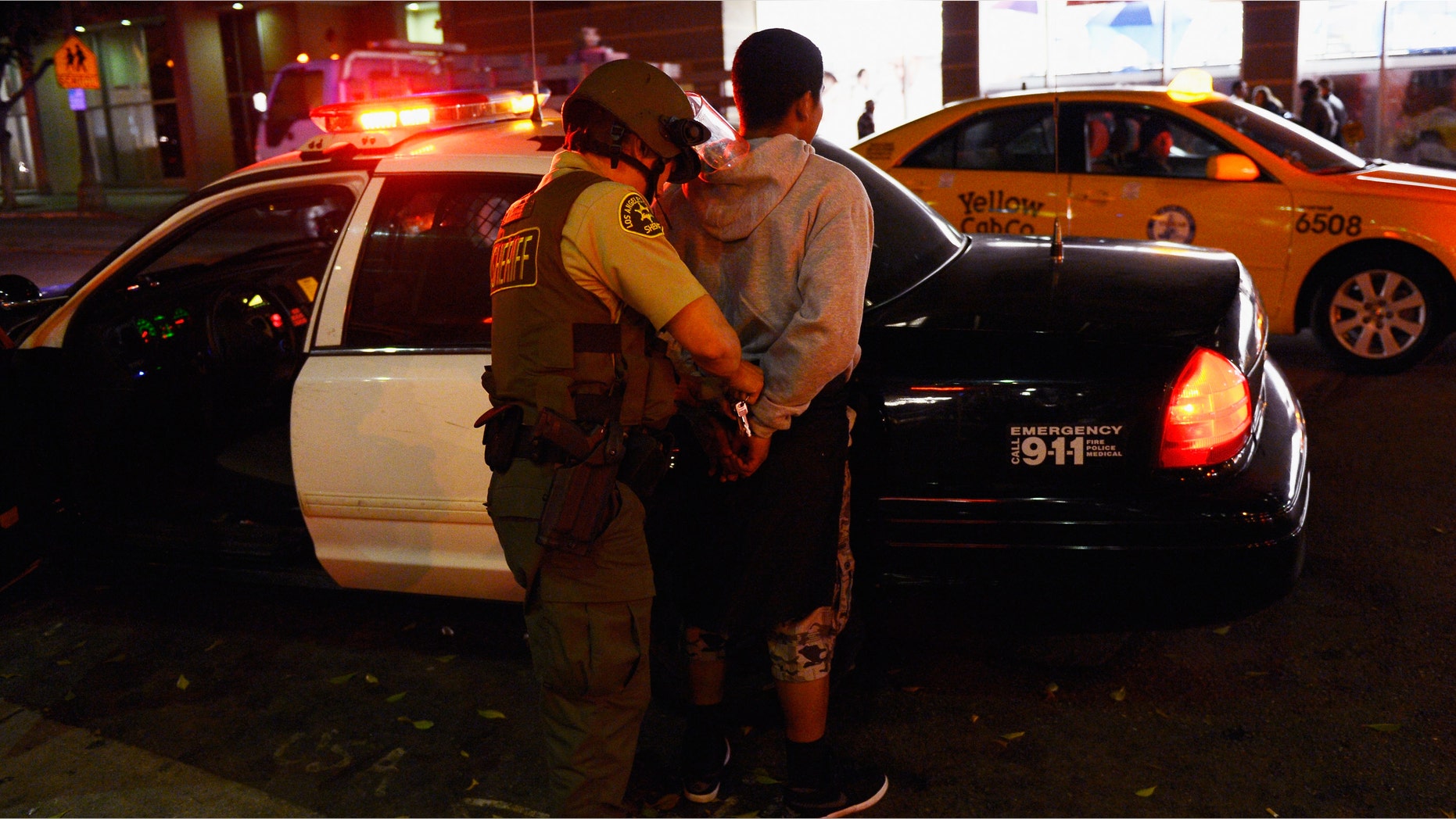 LOS ANGELES, CA - JUNE 11: A Los Angeles County Sheriff's Deputy releases a man after detaining him during disturbances after the Los Angeles Kings defeated the New Jersey Devils to win the 2012 Stanley Cup Final June 11, 2012 in Los Angeles, California. The win is the Kings first NHL championship in franchise history. (Photo by Kevork Djansezian/Getty Images)