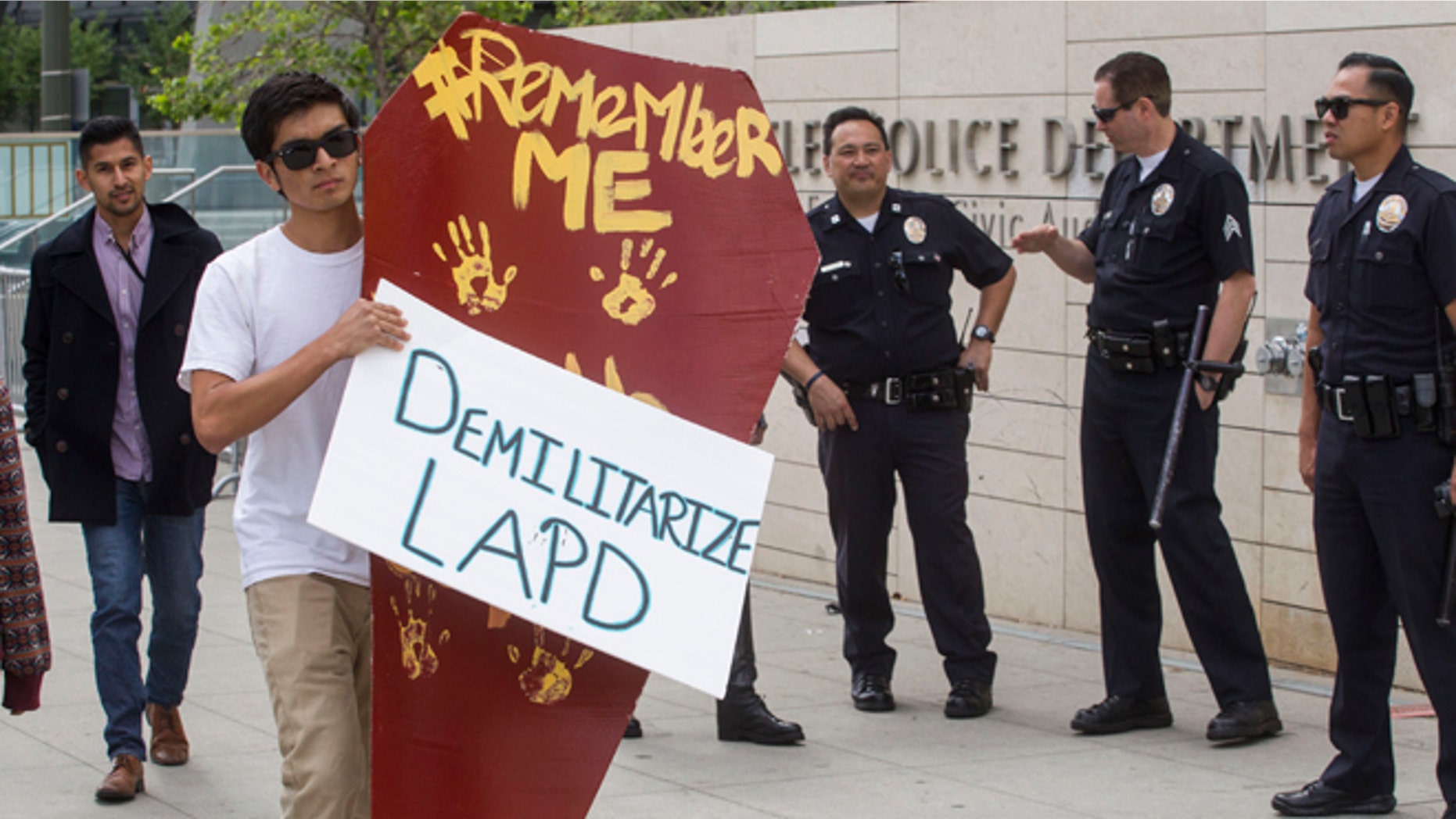 LOS ANGELES, CA - APRIL 7: A demonstrator carrying a makeshift coffin walks past the Los Angeles Police Department Headquarters on April 7, 2015 in Los Angeles, California. The 'Remember Me' march was organized in downtown L.A. for people who have been killed by law enforcement. (Photo by Ringo Chiu/Getty Images)
