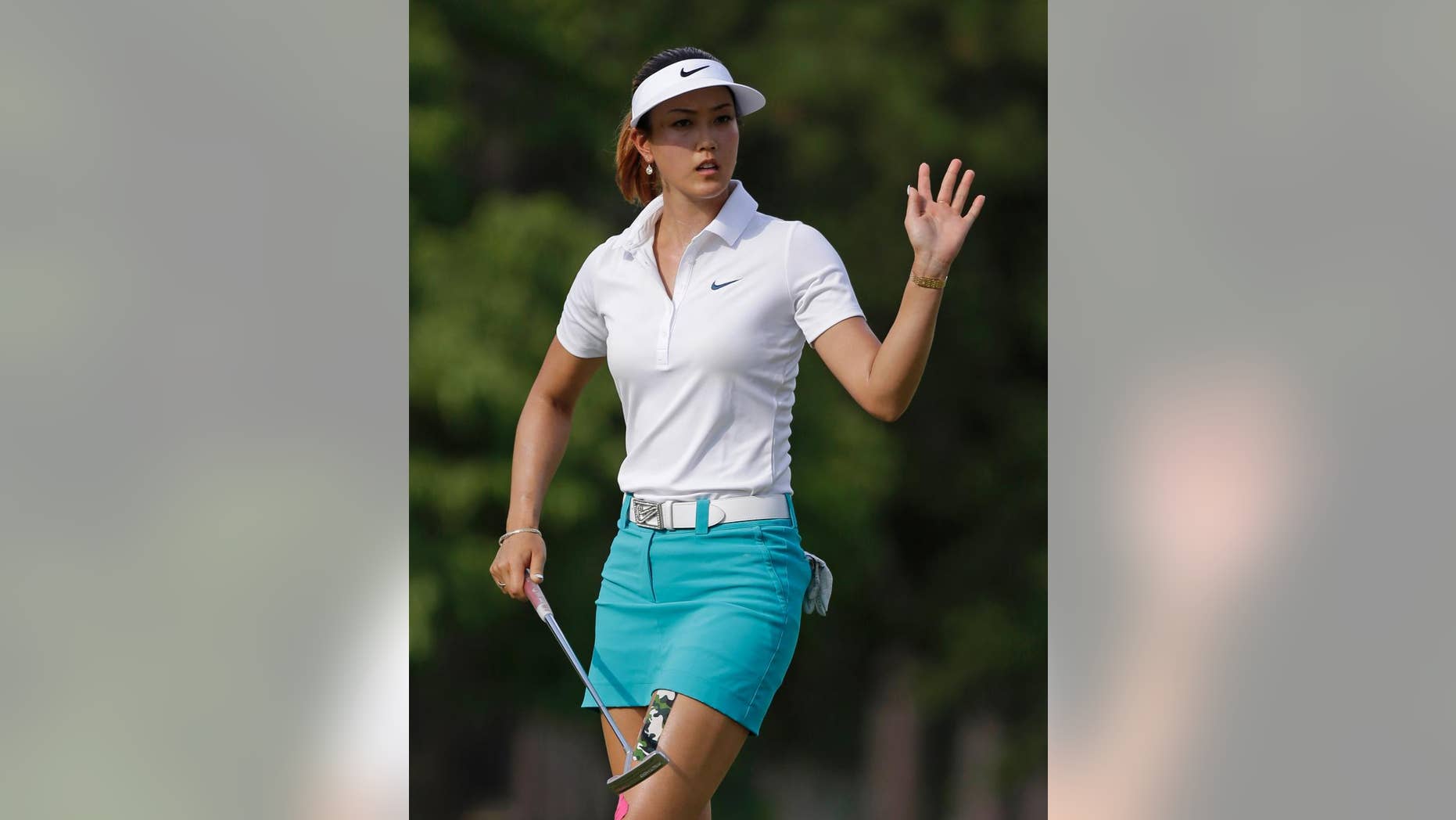 Michelle Wie waves after making a putt on the 14th hole during the first round of the LPGA U.S. Women's Open golf tournament in Pinehurst, N.C., Thursday, June 19, 2014. (AP Photo/Bob Leverone)