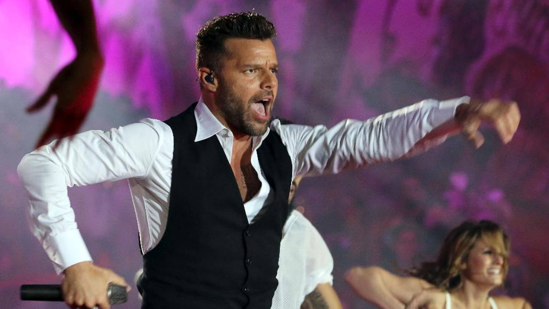 FILE - In this May 31, 2014 file photo, Ricky Martin performs during the opening ceremony of the Life Ball in front of City Hall in Vienna, Austria. Televisa announced Thursday, July 24, 2014, that Martin will be a coach in the fourth season of “La Voz...Mexico,” or "The Voice...Mexico," which premieres September 7. The Puerto Rican singer was previously a coach on the Australian version of “The Voice.” (AP Photo/Ronald Zak, File)