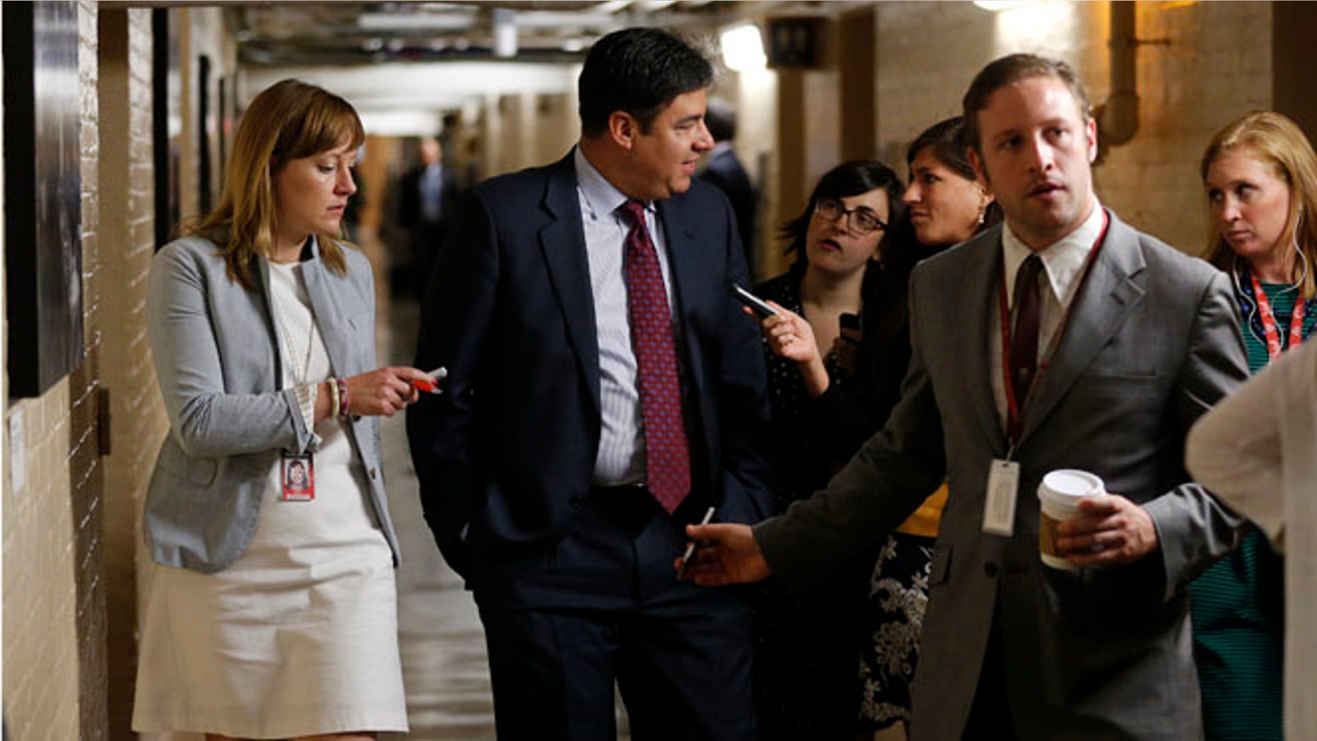 US Representative Raul Labrador talks to reporters gathered to ask members about House Majority Leader Eric Cantor's Republican primary election defeat in a hallway of the U.S. Capitol in Washington on June 11, 2014.